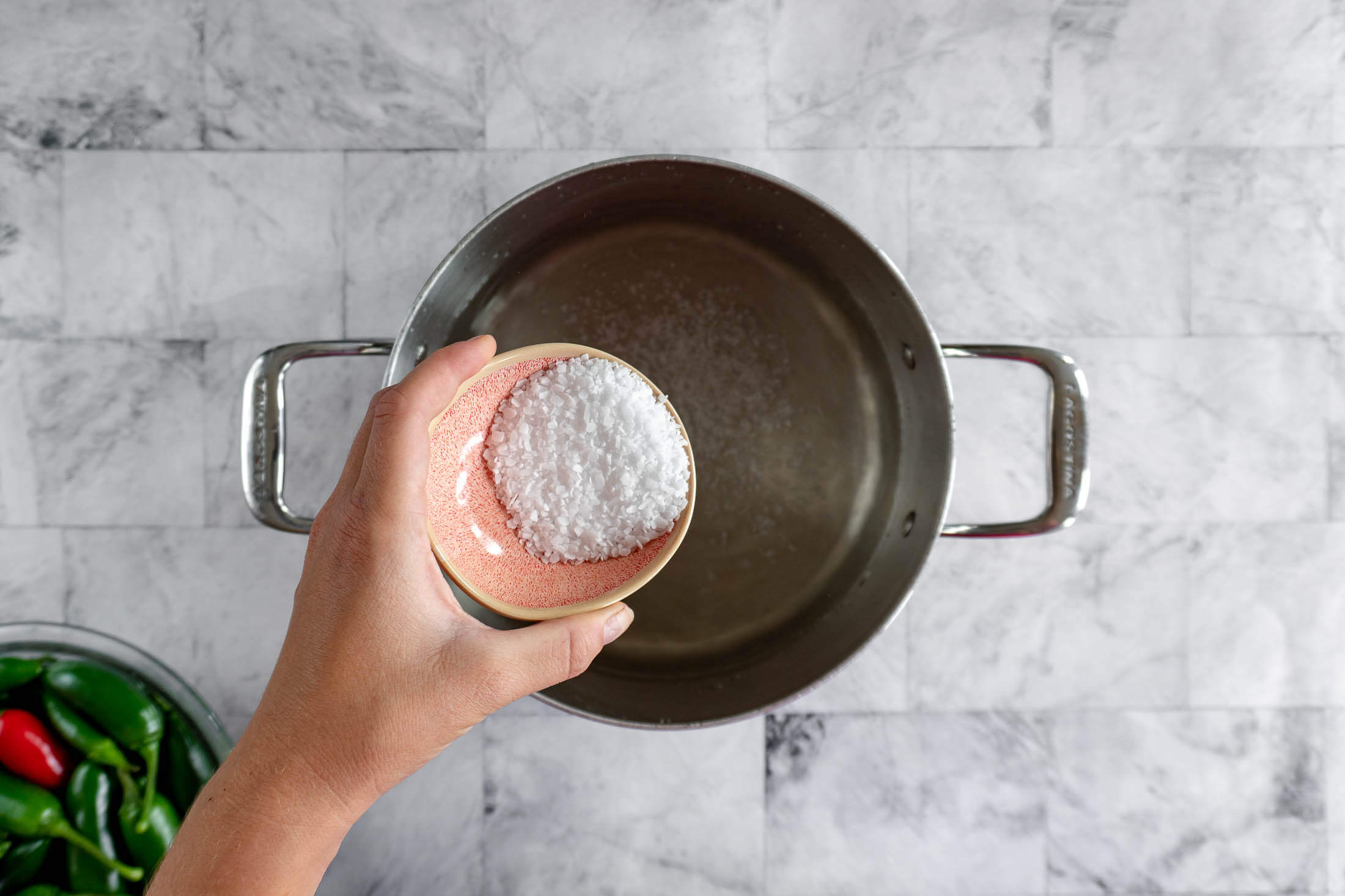 Adding pickling salt to the vinegar and water brine. 