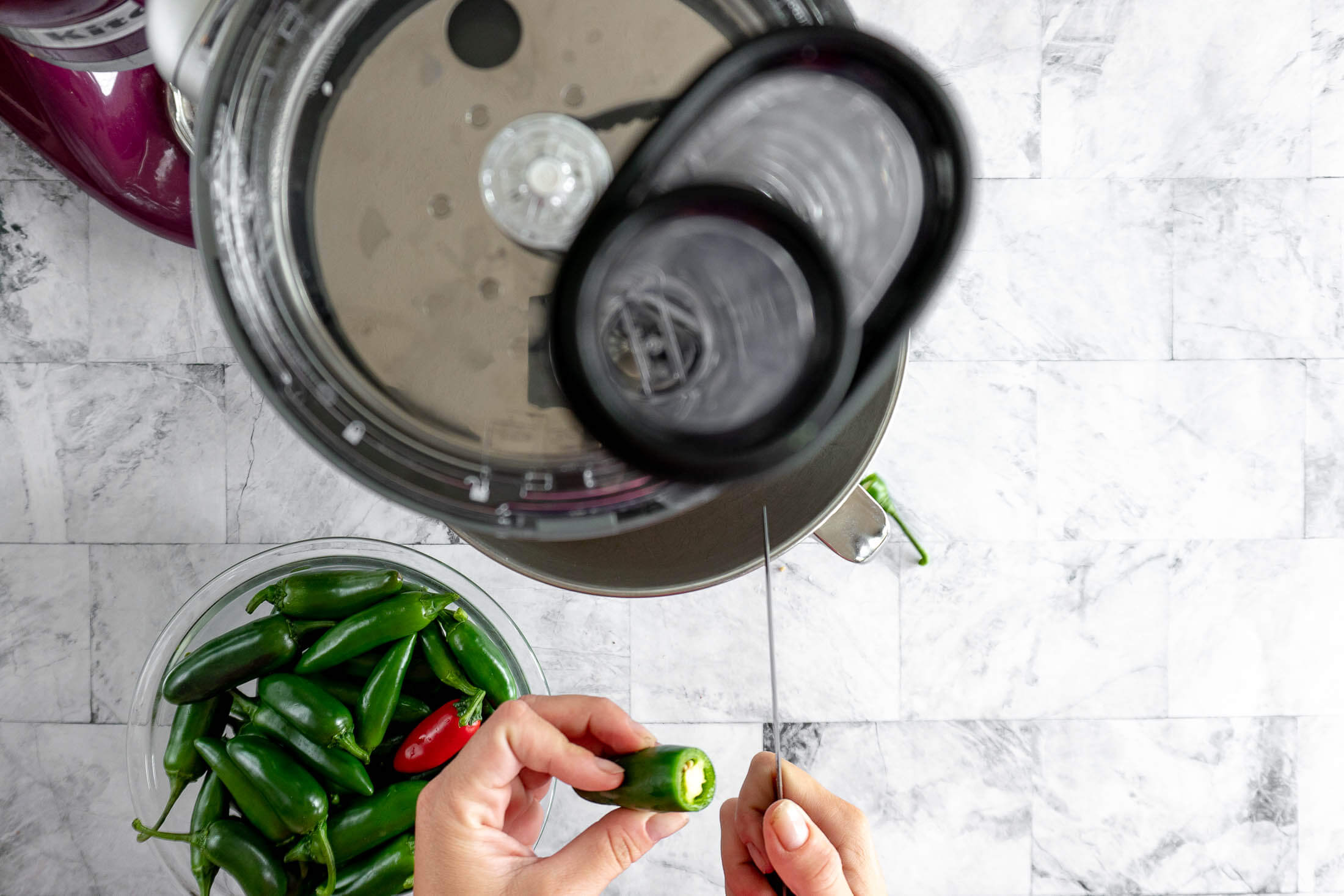 Slicing the stem off a jalapeño before slicing it into rings. 