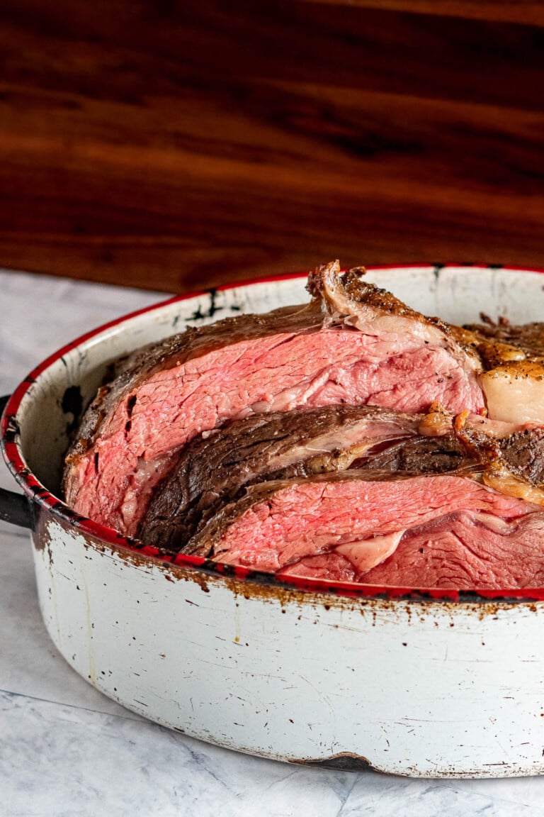 Sliced sous vide prime rib in a roasting pan.