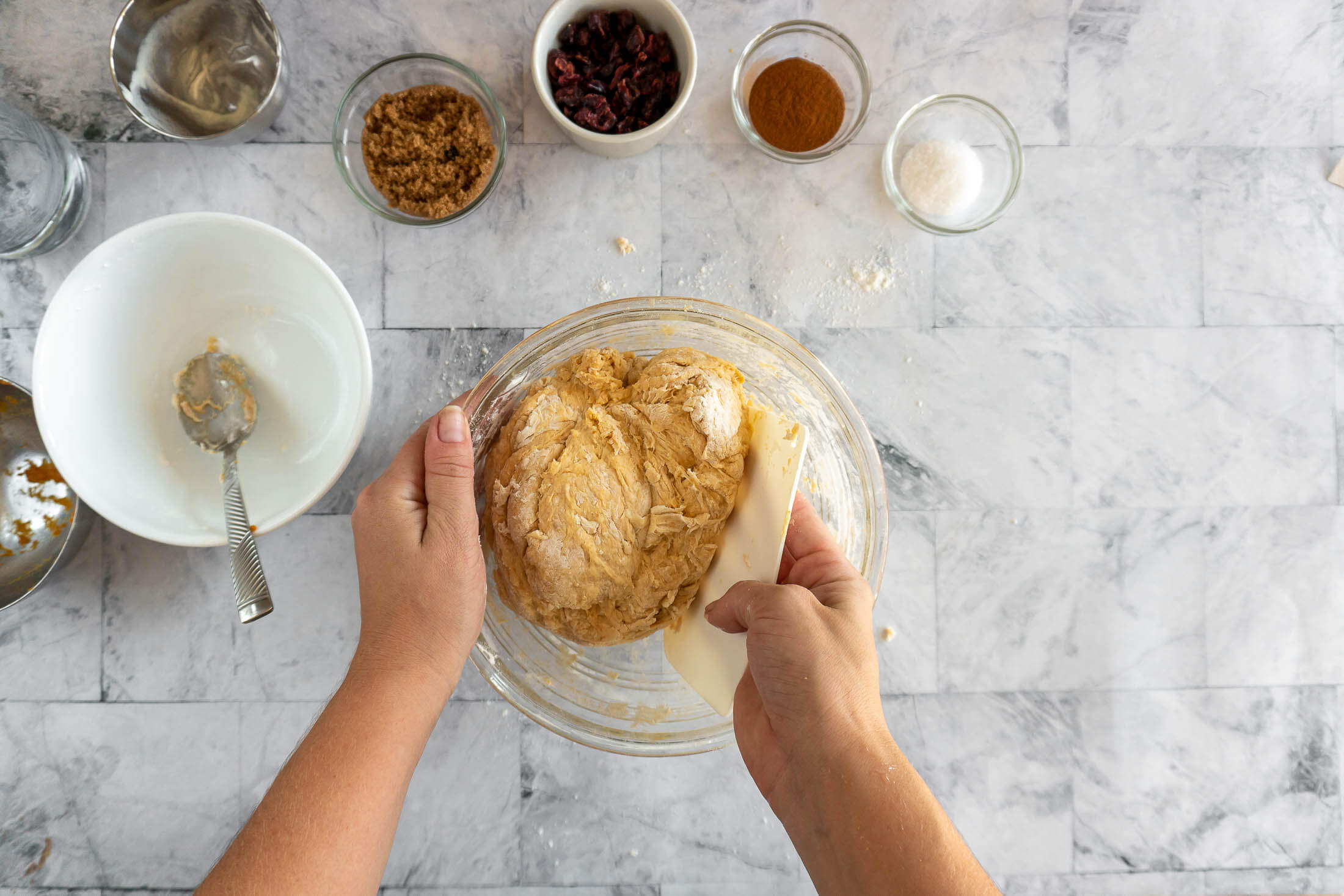Folding in the flour with a bowl scraper.