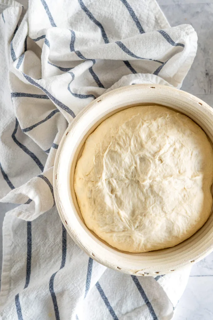 Sourdough bread proofing in a round banneton.