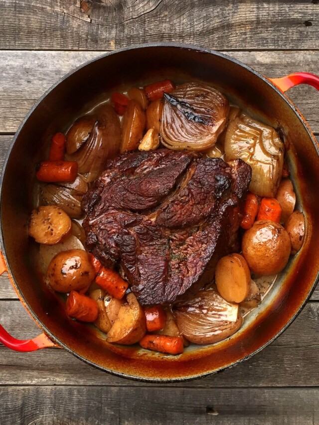 Pot roast in a red cast iron dutch oven.