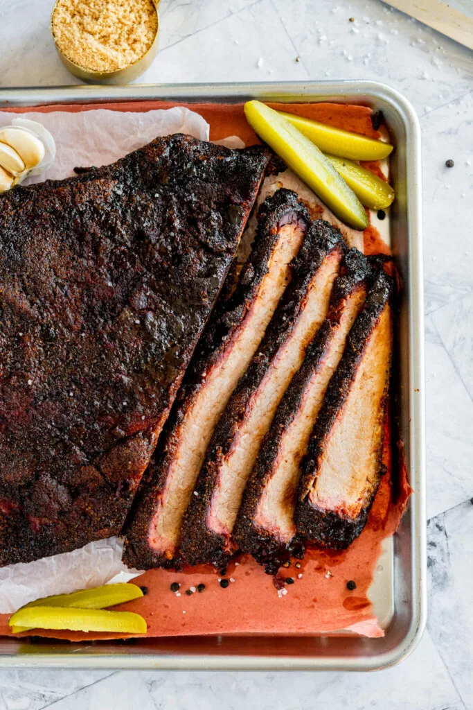 Sliced smoked brisket on a tray.
