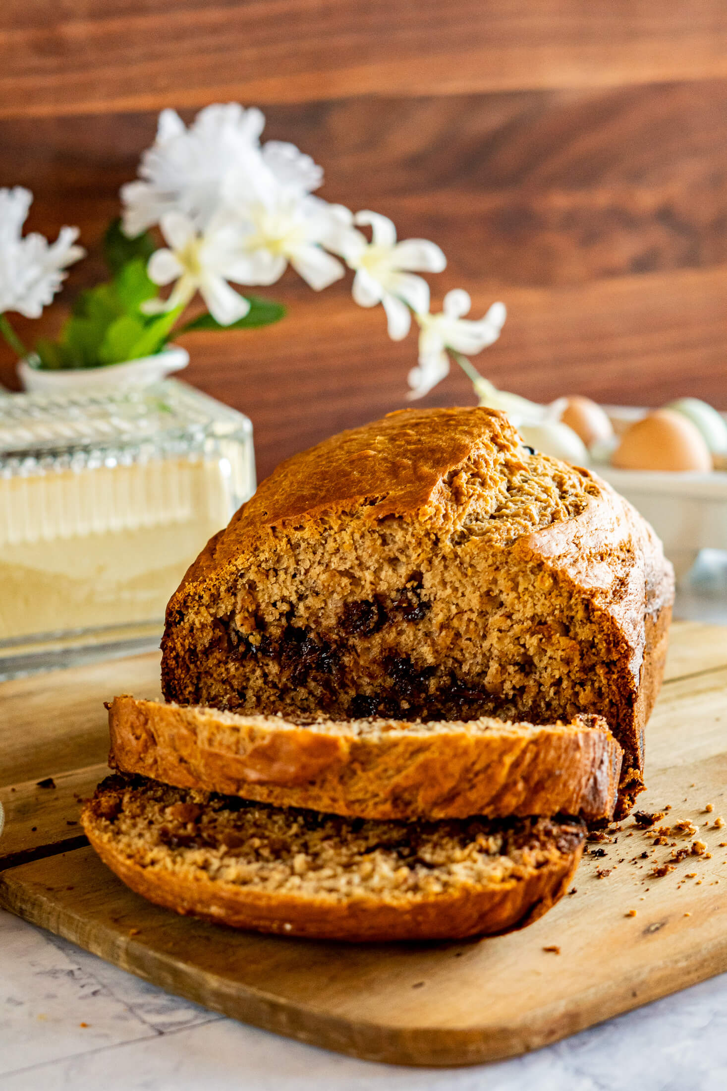 Sliced loaf of bread machine banana bread on a wooden cutting board. 