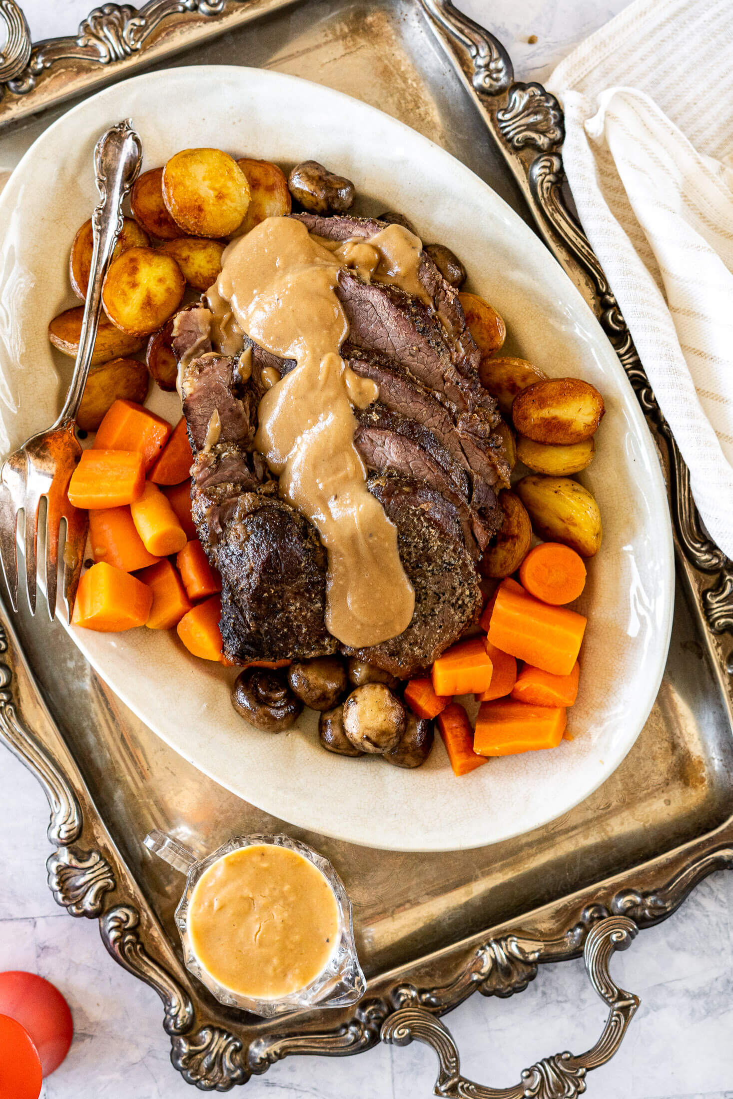 Cooked cross rib roast with baby potatoes, carrots, mushrooms and gravy.