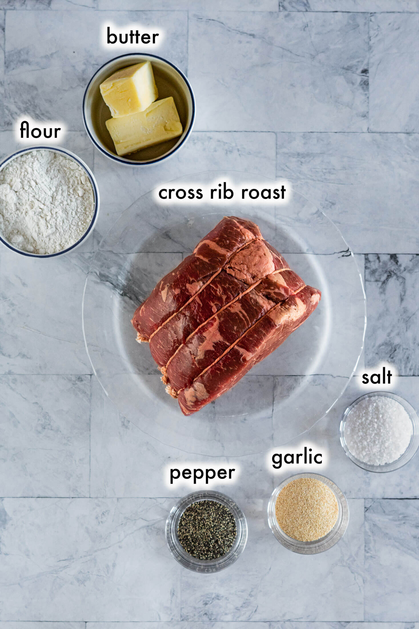 Prepared ingredients in bowls, labeled: butter, flour, cross rib roast, salt, pepper, garlic powder.