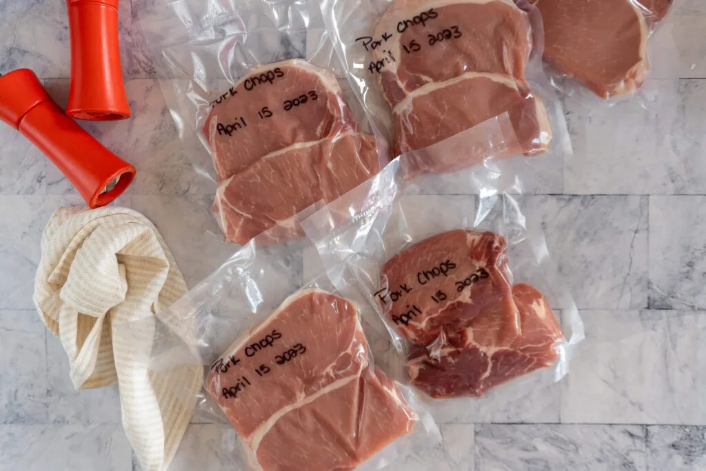 Frozen and labeled pork chops in vacuum sealed bags.