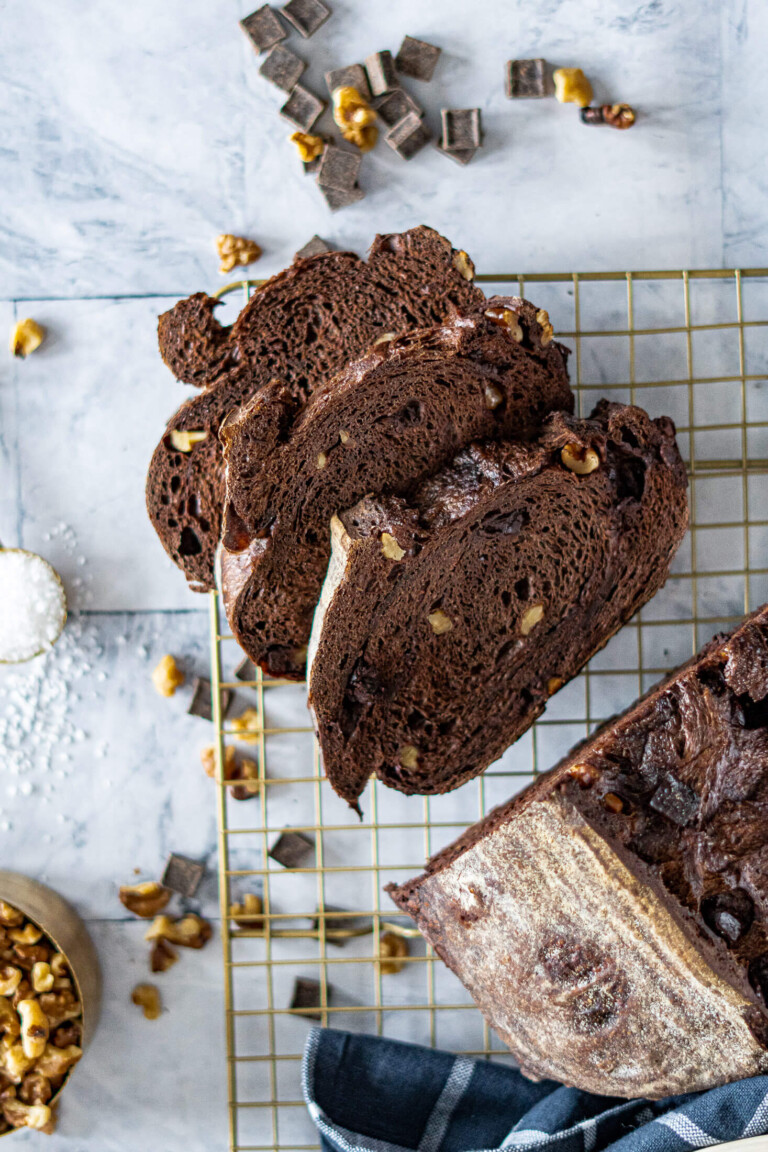Sliced chocolate sourdough loaf with chocolate chunks and walnuts.