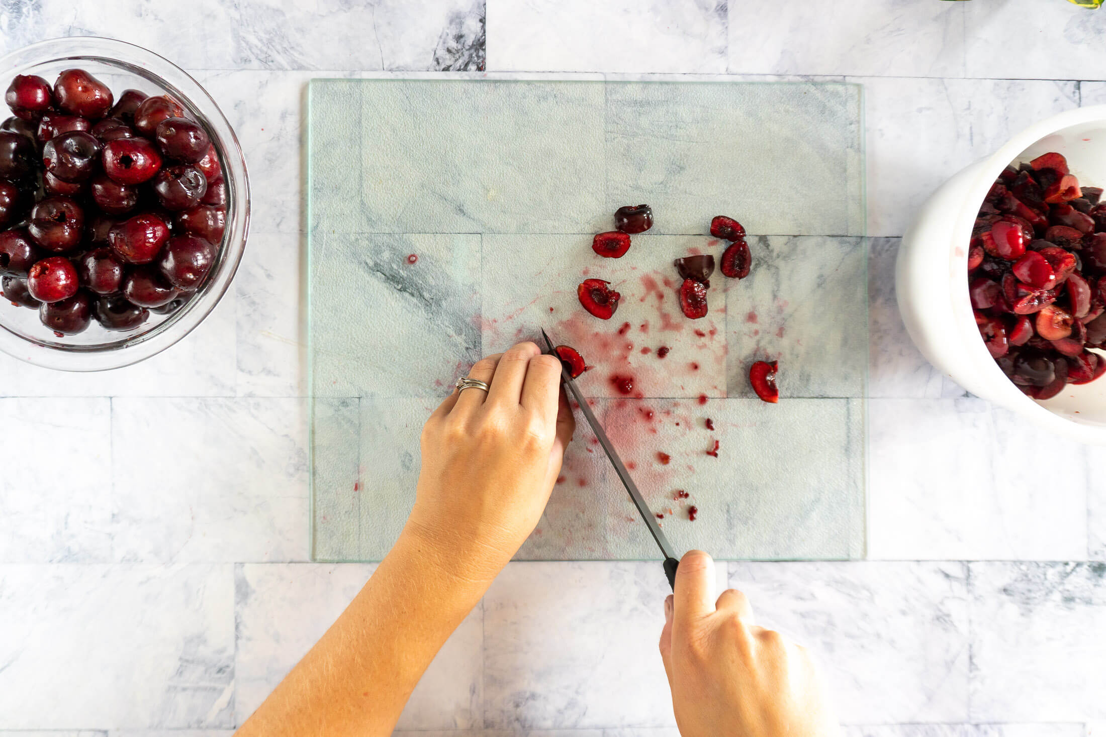Slicing pitted cherries into quarters.