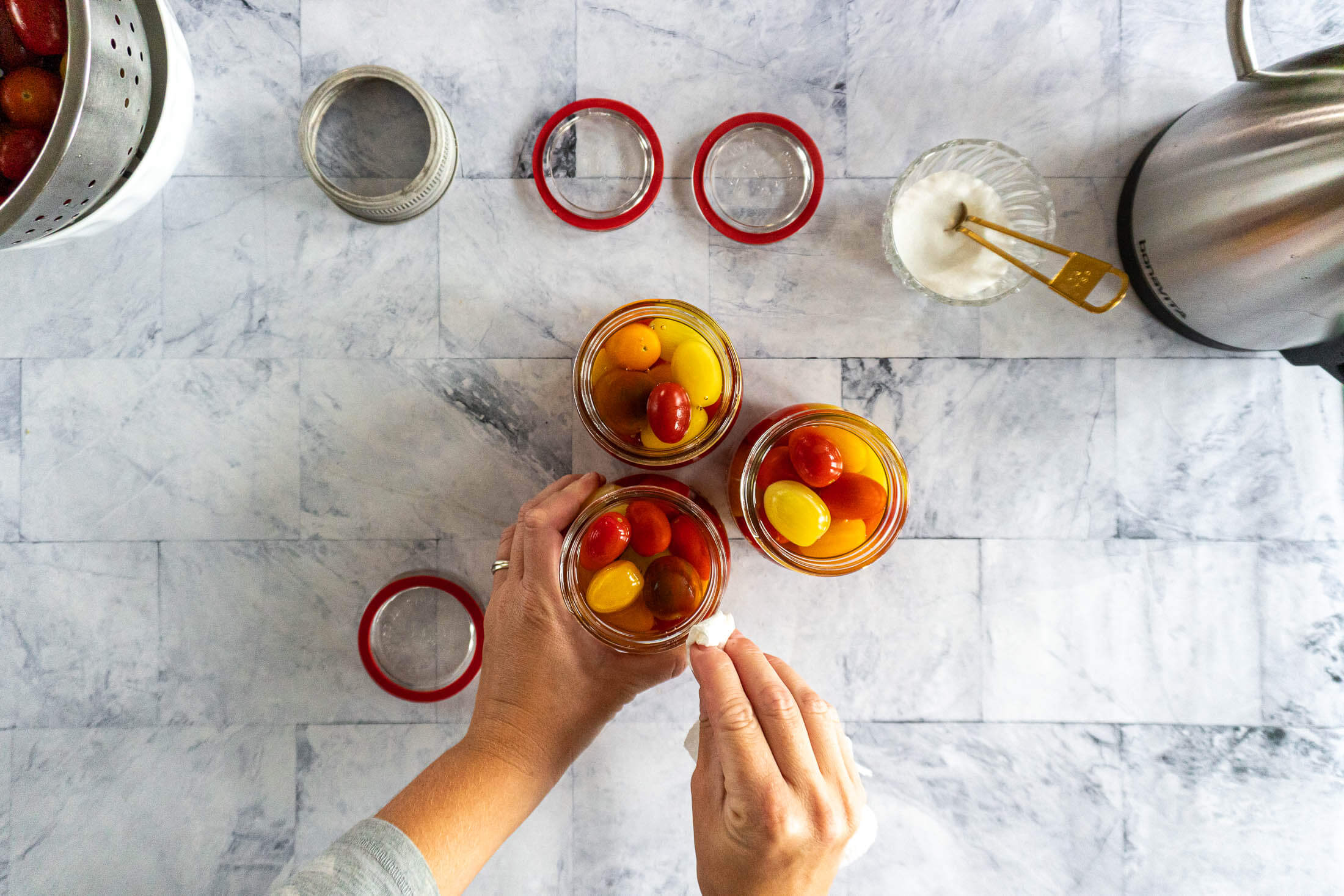 Wiping rims of each mason jar.