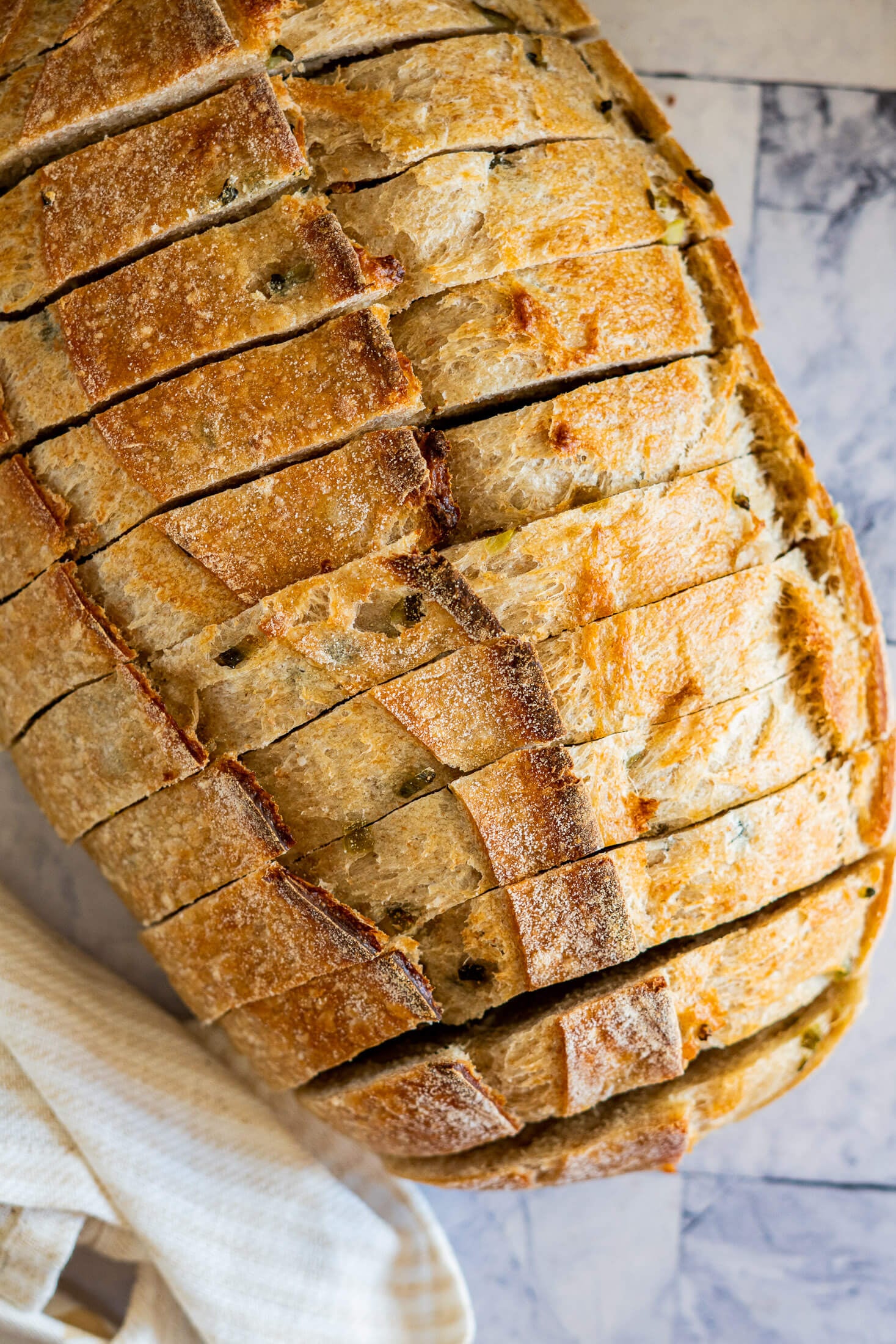 Pickle sourdough bread sliced and ready to serve on a cutting board.