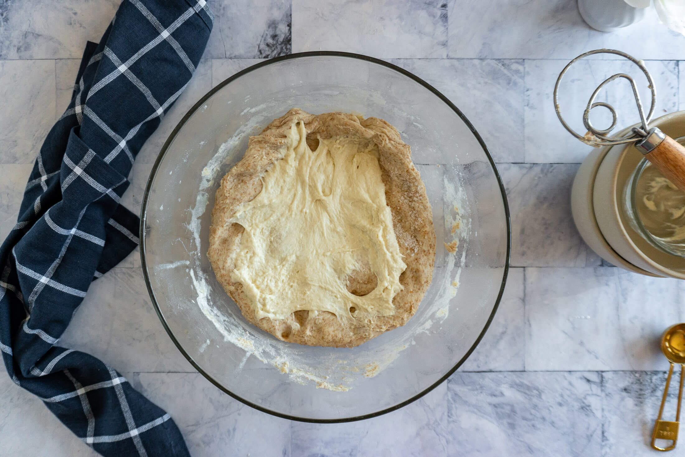 Spreading sourdough starter and salt over top of the dough.