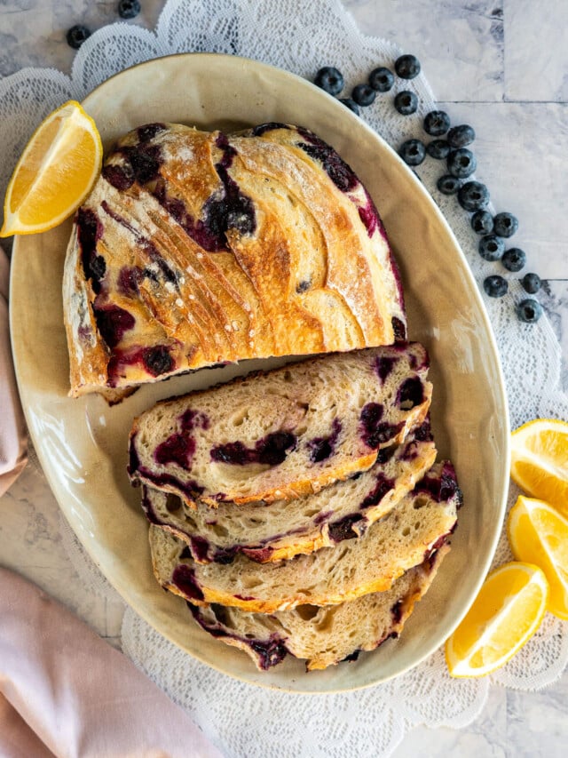 Sliced lemon blueberry sourdough bread on a platter.