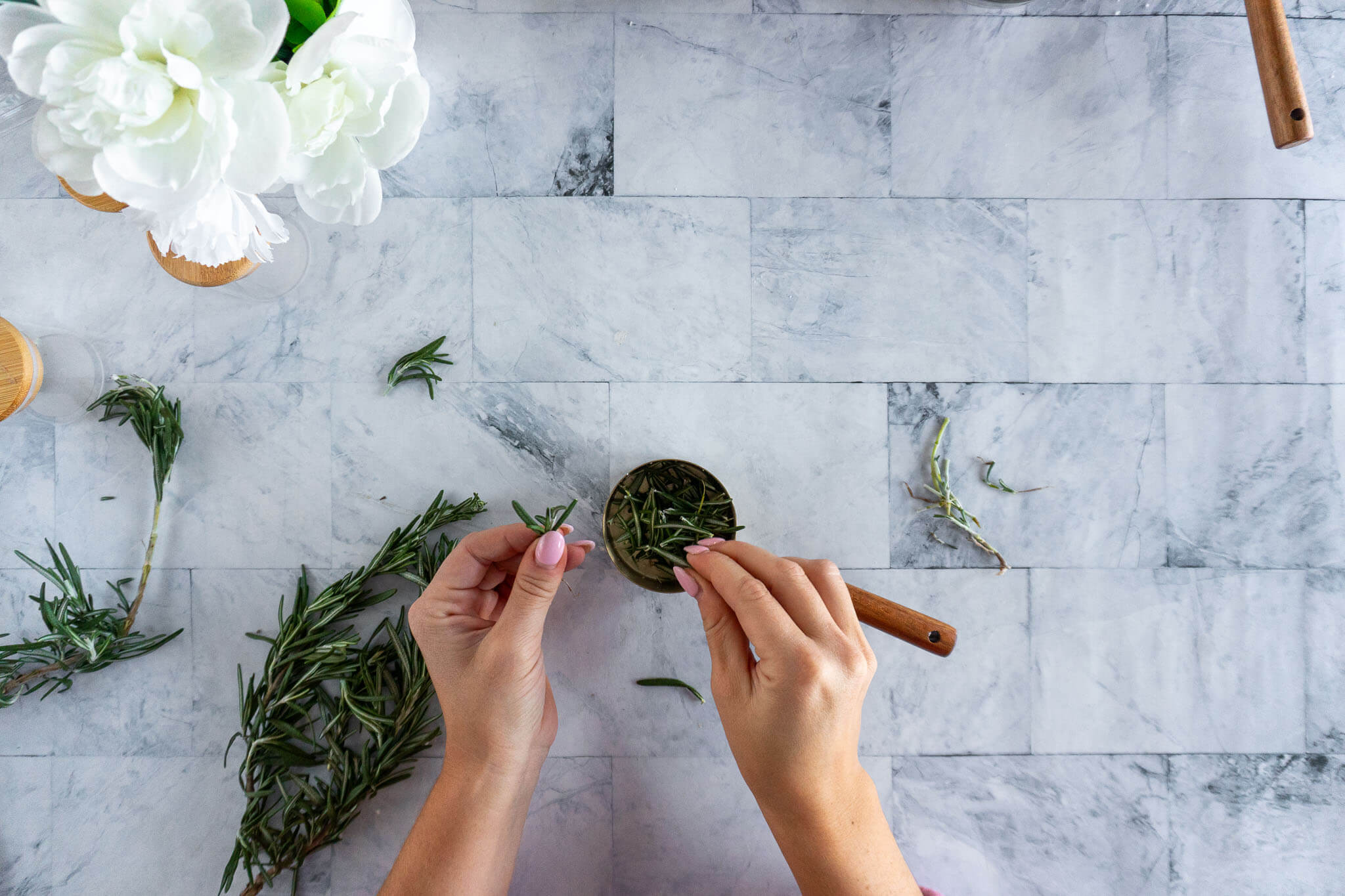 Picking rosemary leaves from the stems.