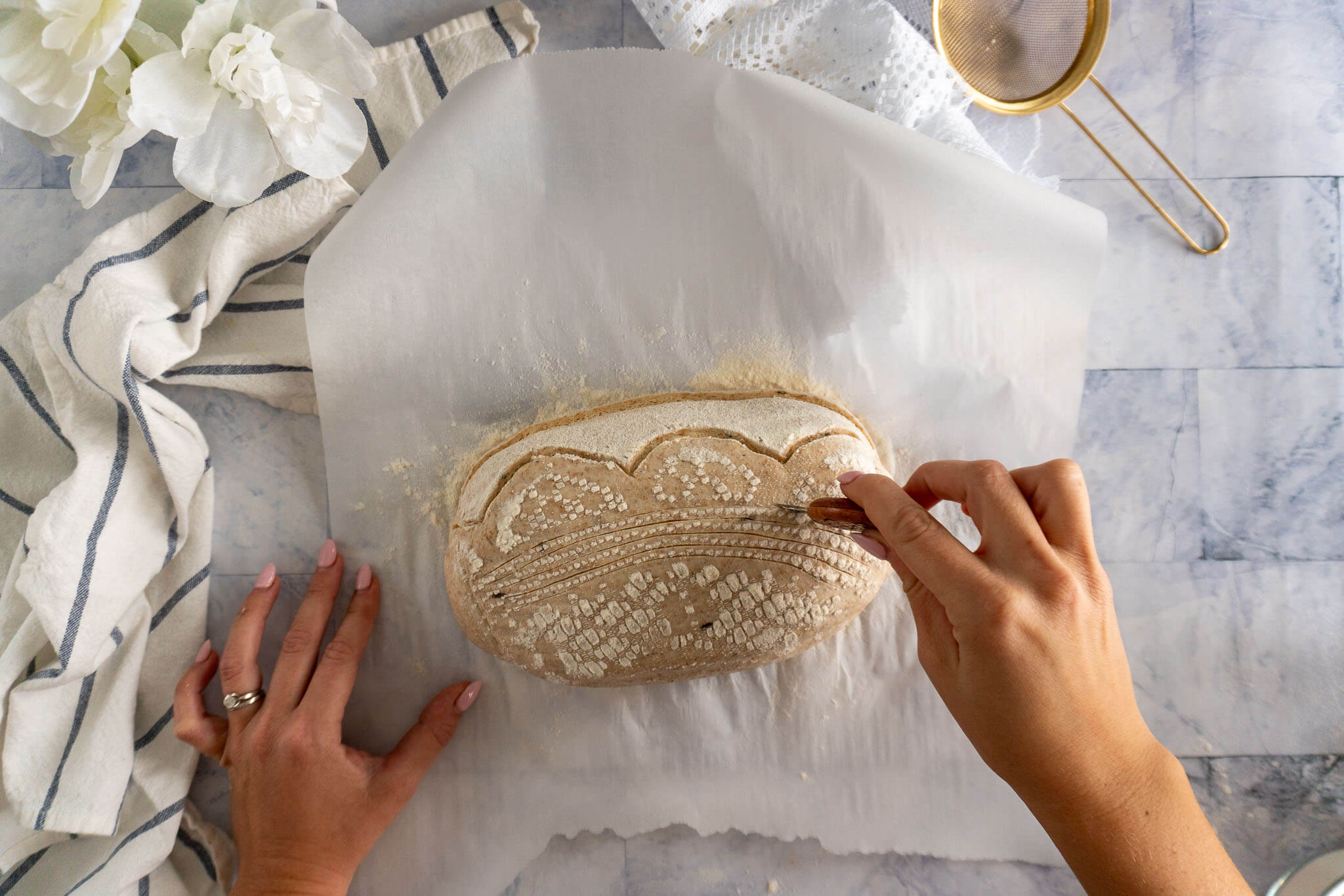 Scoring rosemary sourdough bread. 