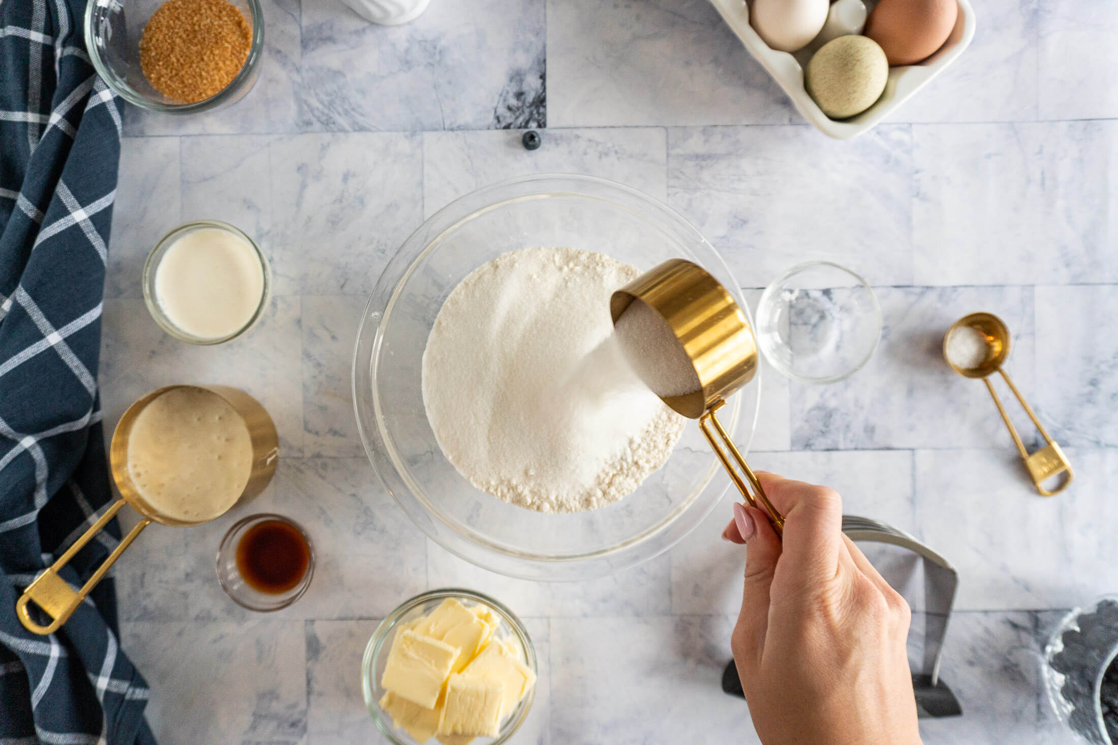 Pouring sugar into a bowl with flour.
