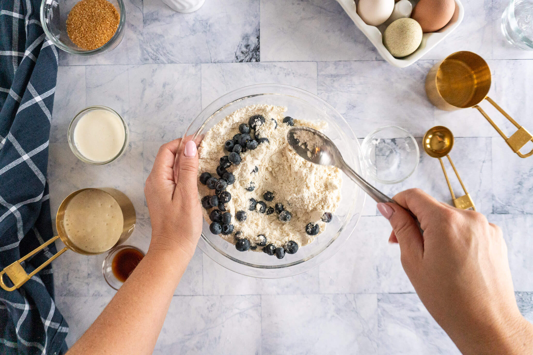 Tossing blueberries in flour to coat.