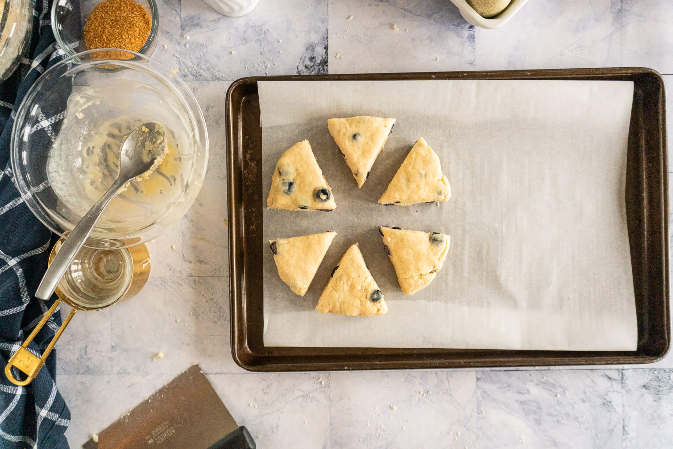 Portioned scone dough on parchment lined baking sheet.