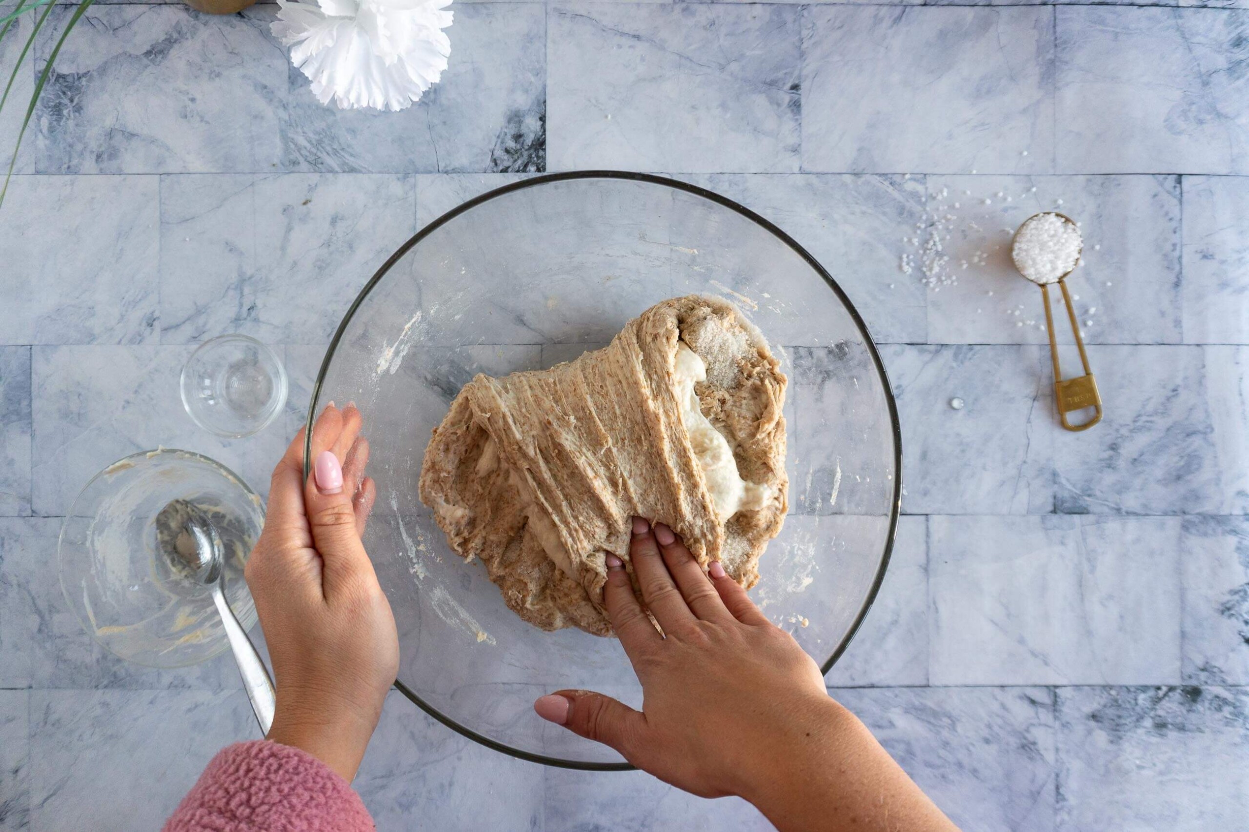 Folding whole wheat sourdough dough over itself to encase the starter.