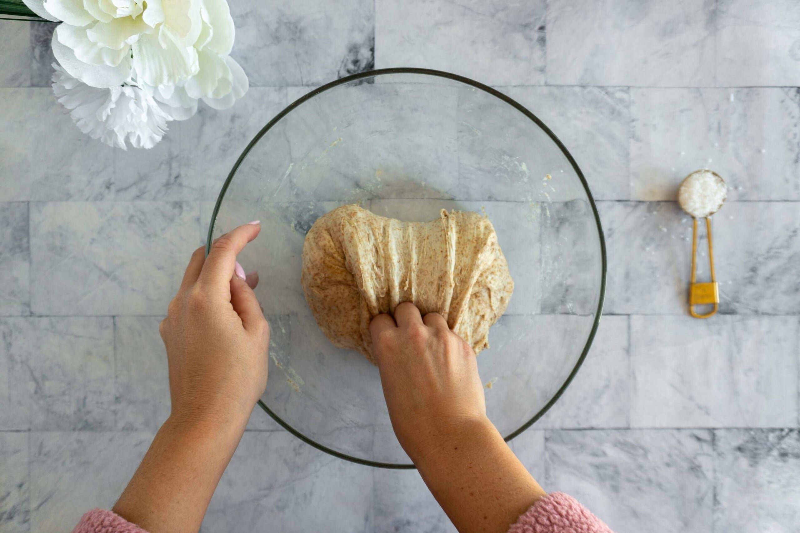 Performing a stretch and fold on whole wheat sourdough dough during bulk fermentation.