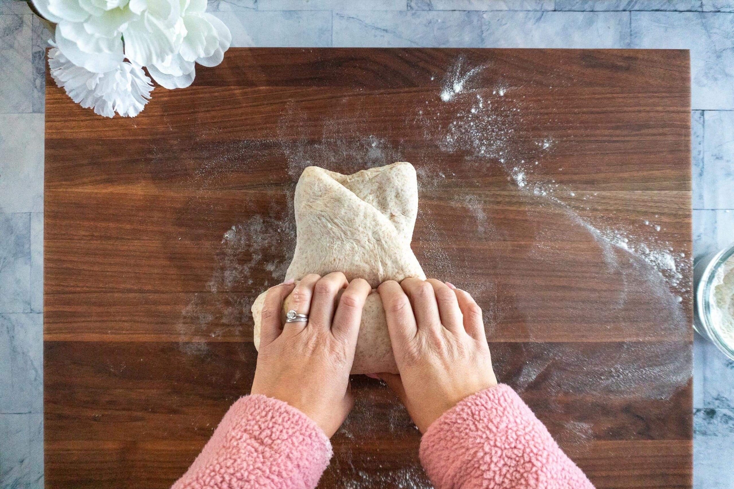 Rolling shaped whole wheat sourdough dough into a log.