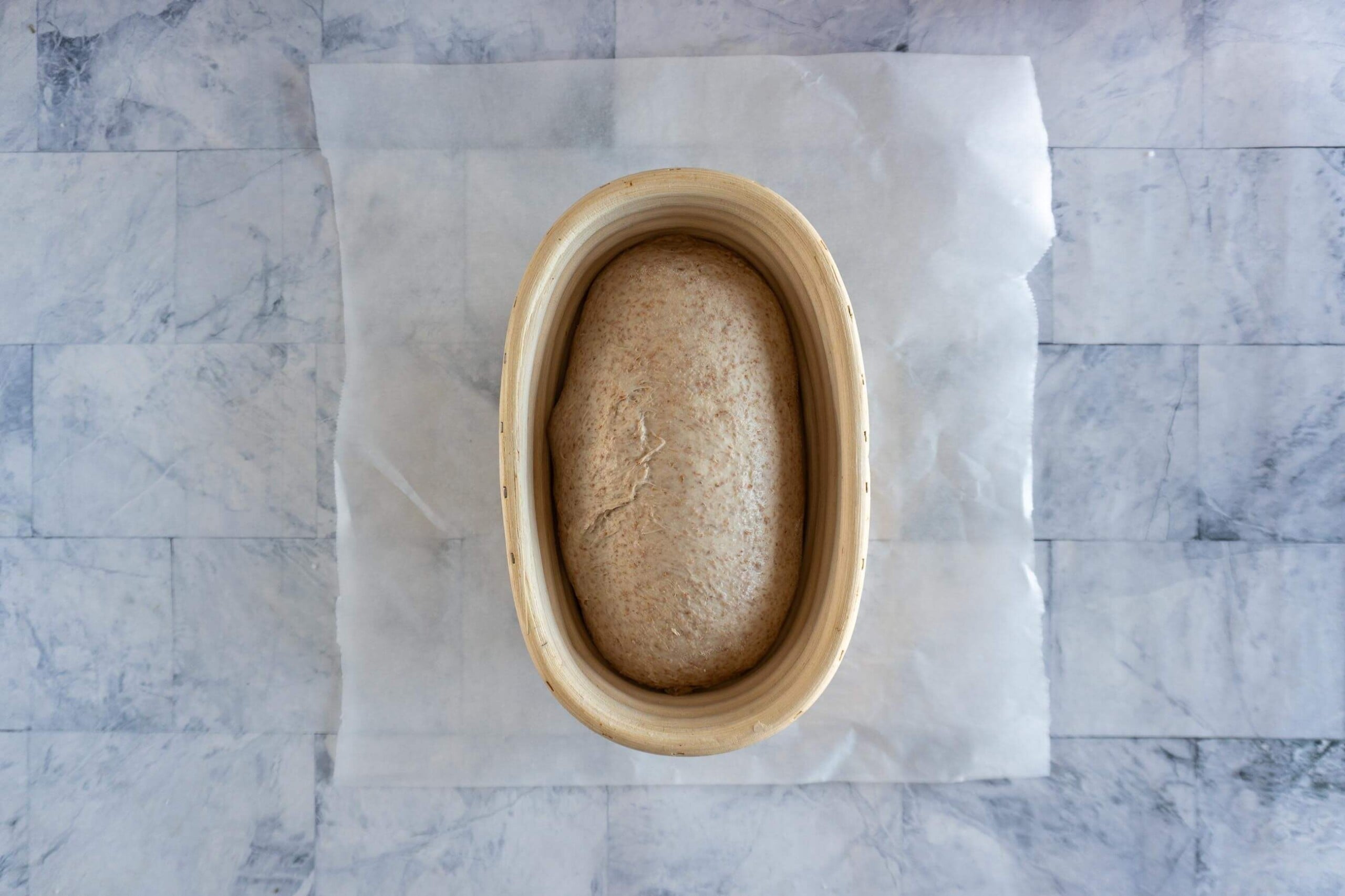 Proved whole wheat sourdough loaf in a banneton ready to bake.