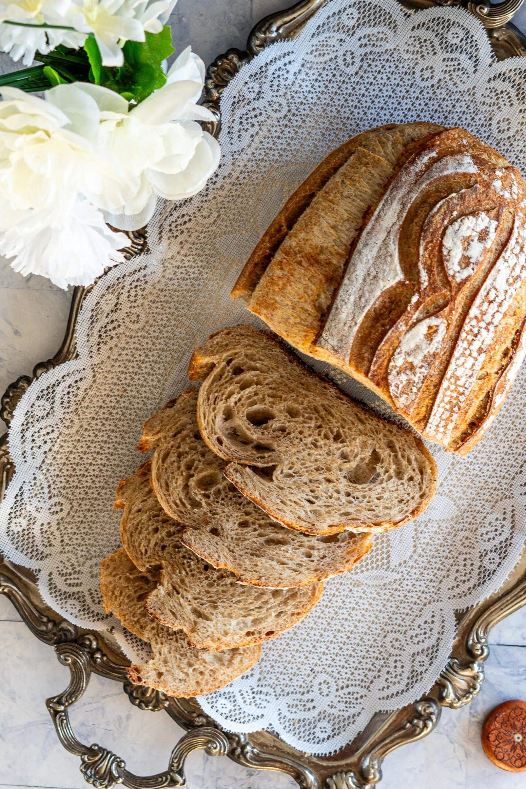 Sliced whole wheat sourdough bread on vintage tray.