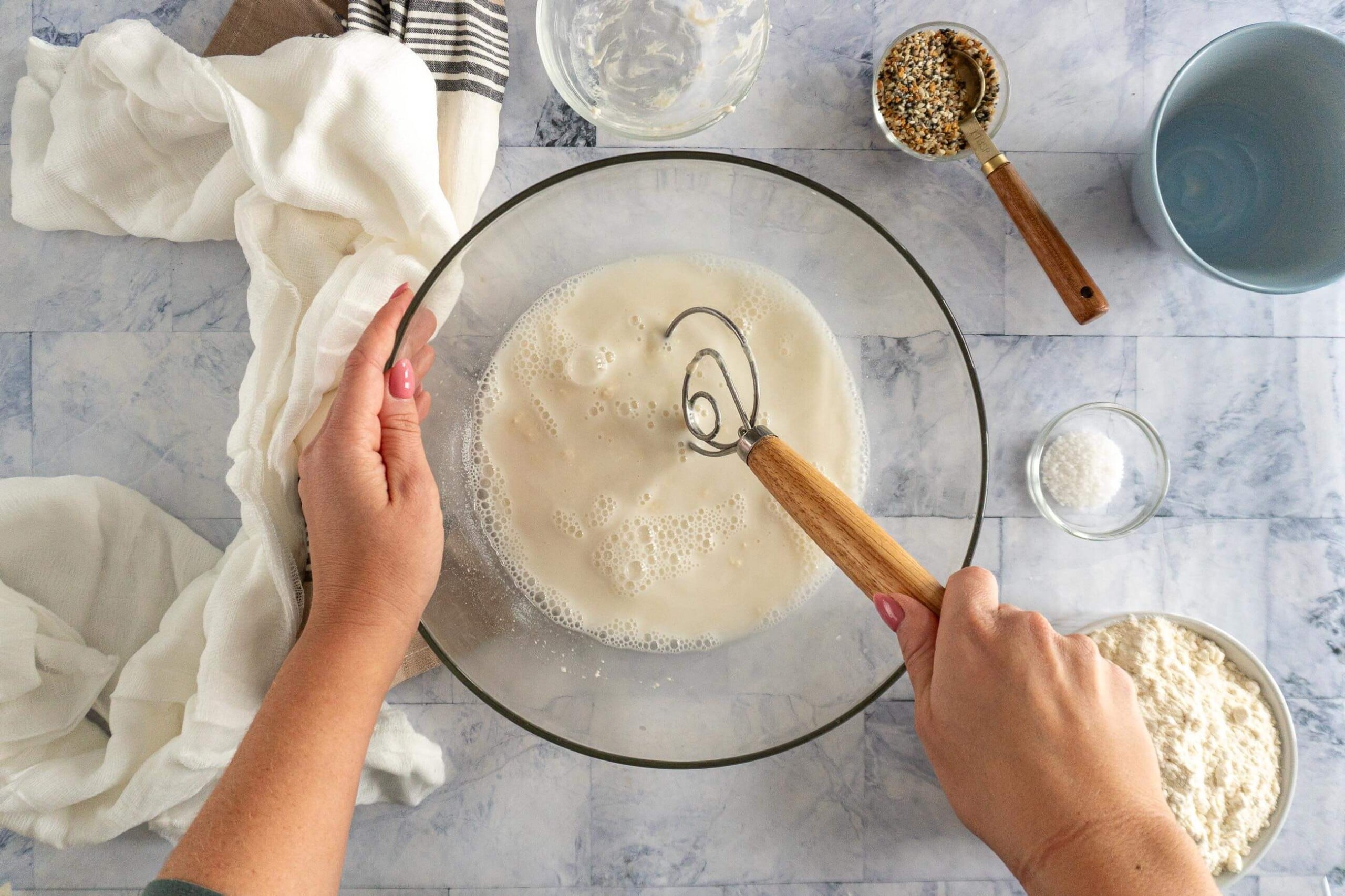 Whisking sourdough starter and water together in a bowl. 