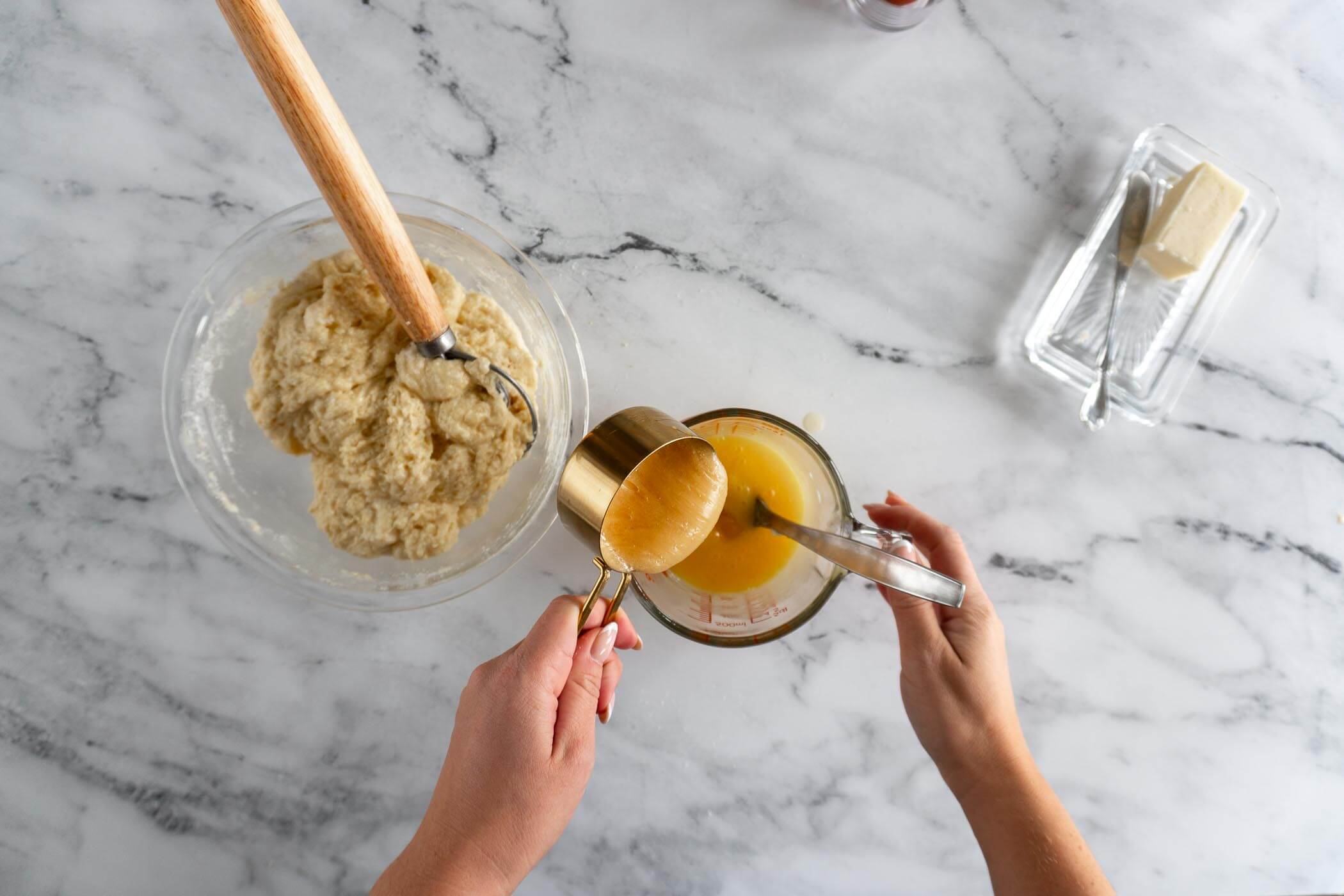 Pouring honey into melted butter and mixing together. 