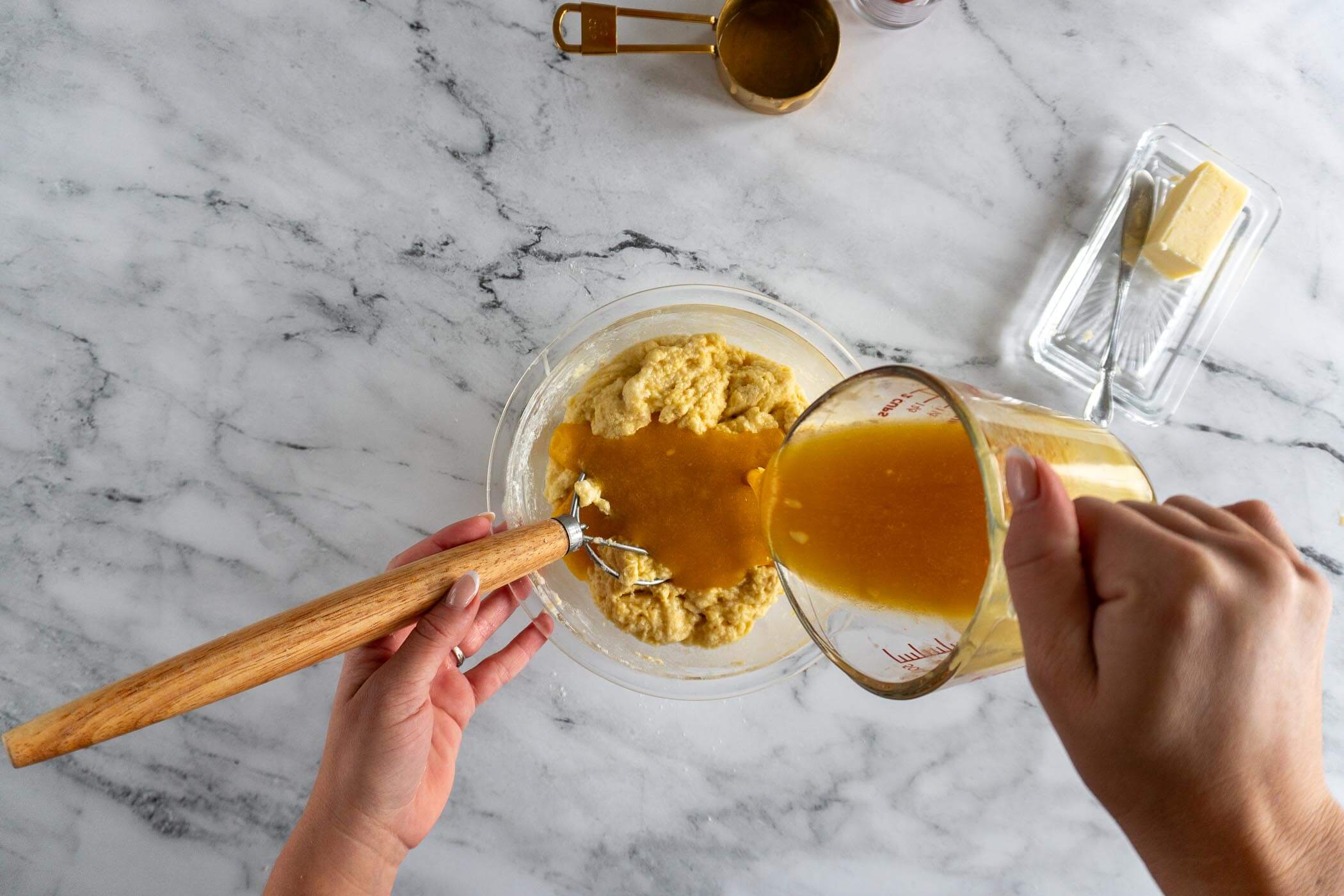 Adding in the melted butter, honey, and eggs to the sourdough cornbread batter. 