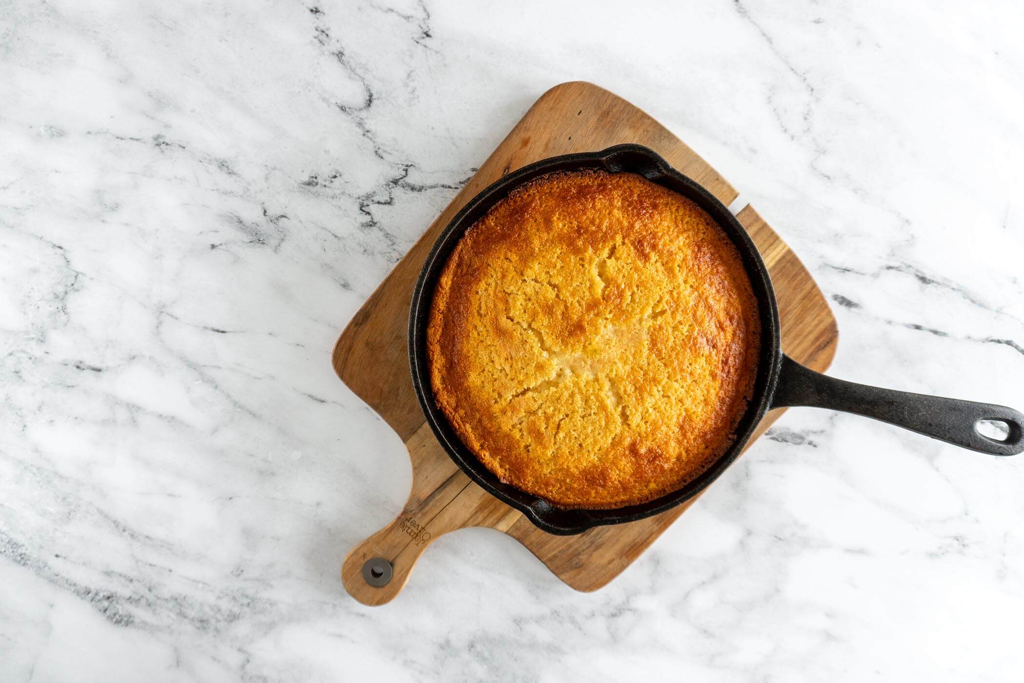 Baked sourdough discard cornbread in a black cast iron skillet. 