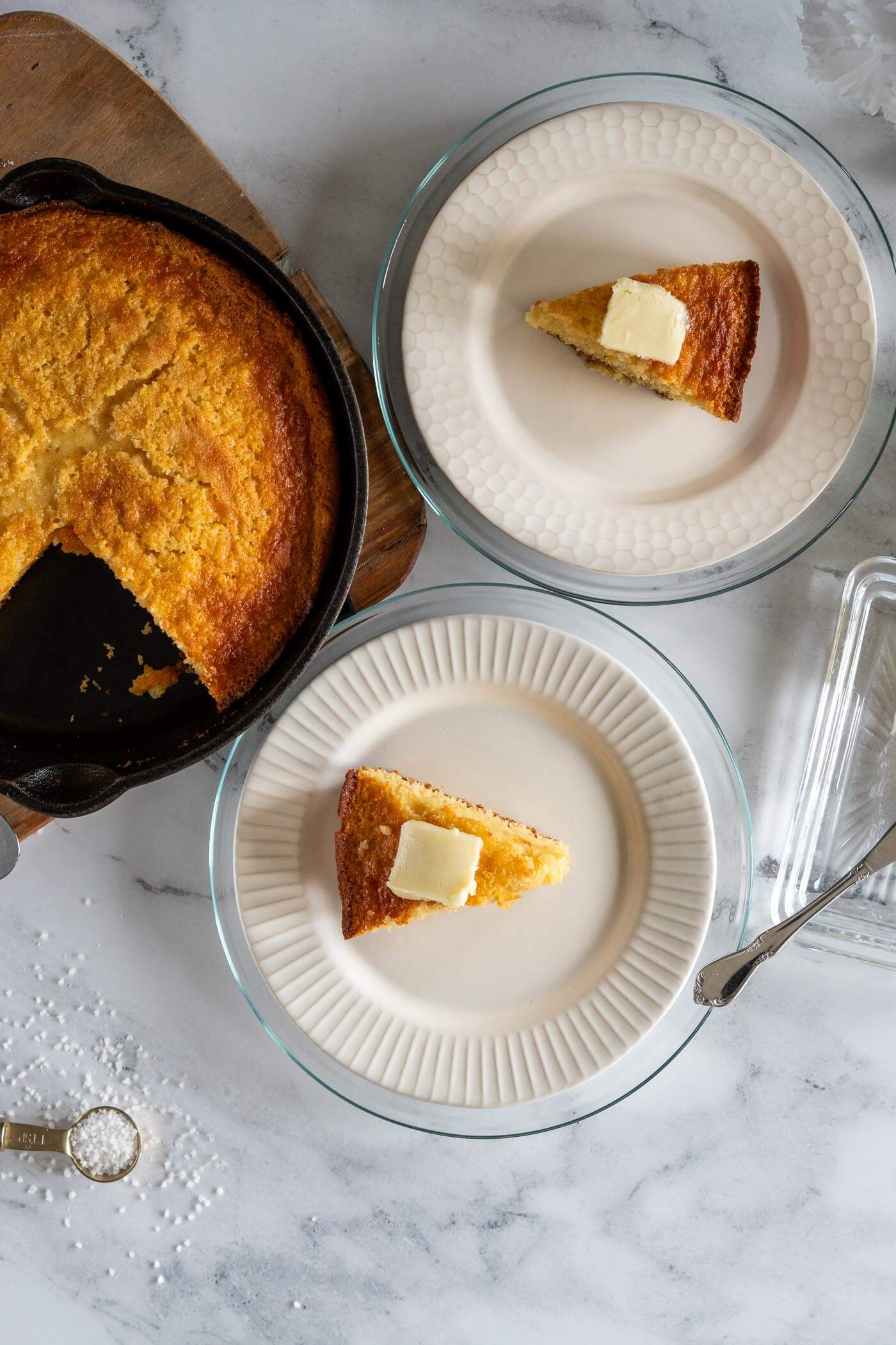 Two wedges of sourdough cornbread with a pat of butter. 