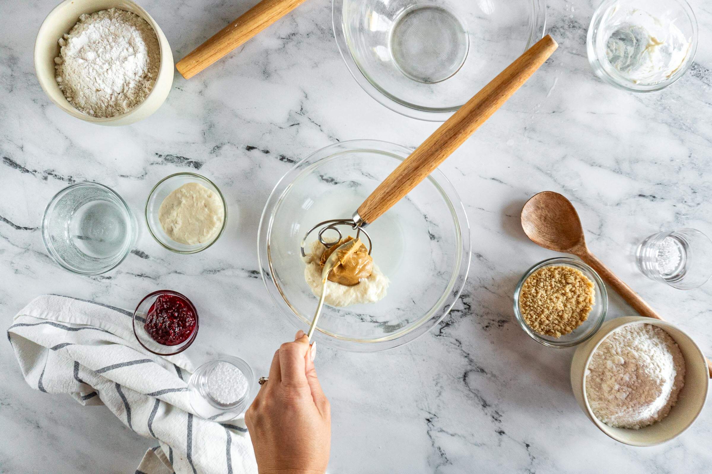 Adding peanut butter to sourdough starter and water. 
