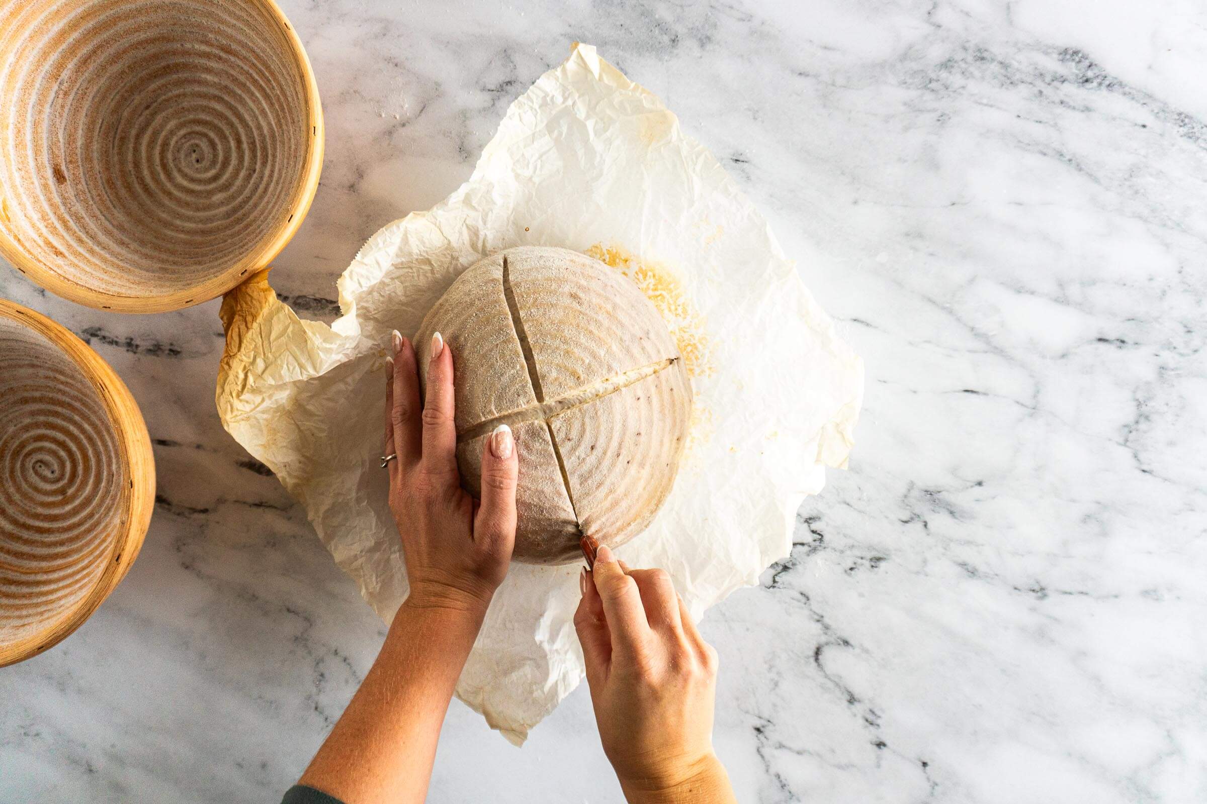 Scoring the dough in a large x pattern. 