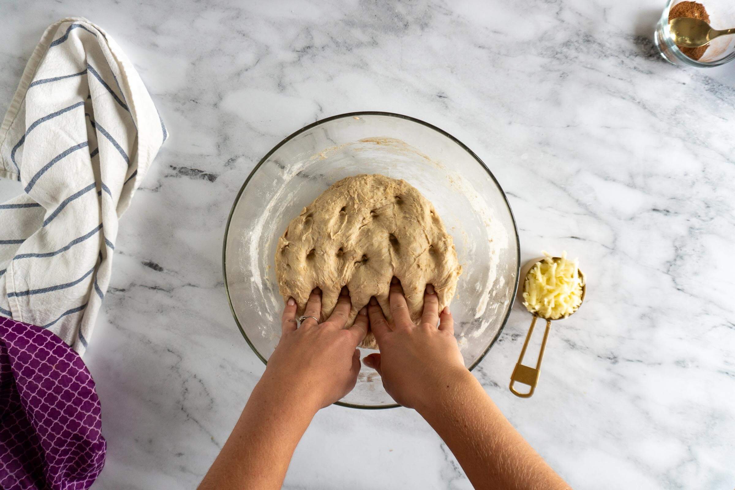 Dimpling the dough by poking with fingers. 