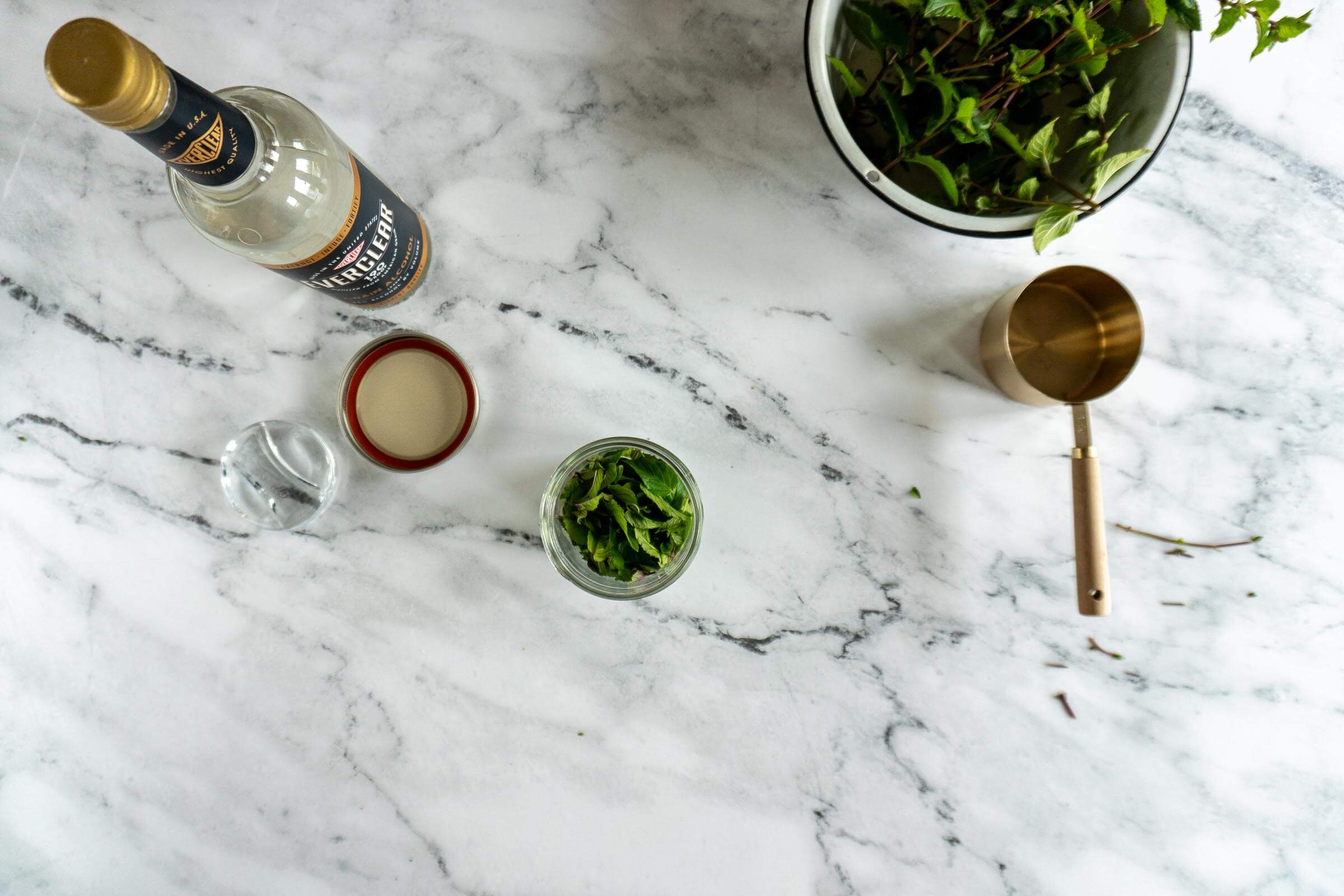 Bruised mint leaves in a mason jar.