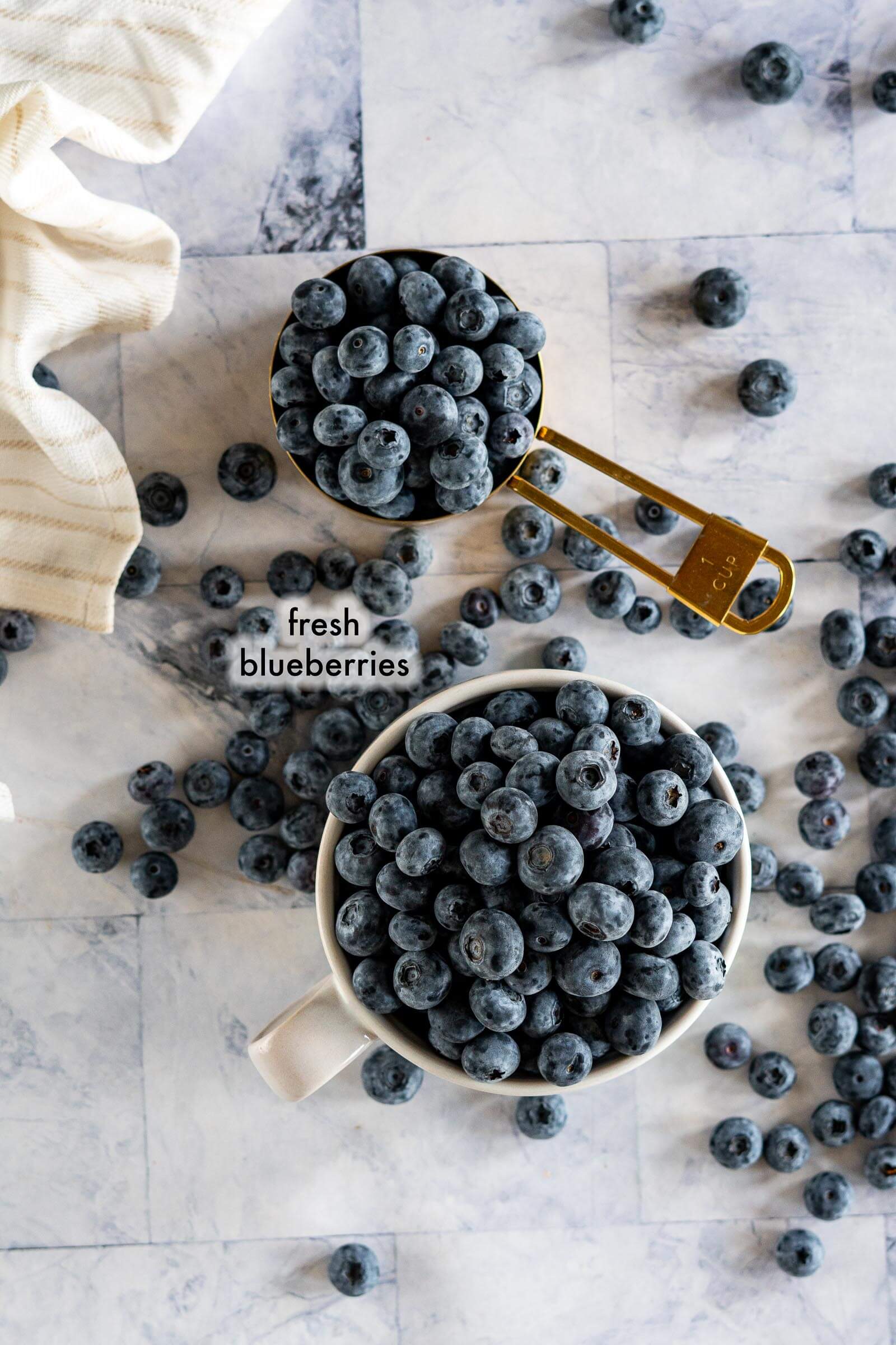 Fresh blueberries in various cups and bowls. 