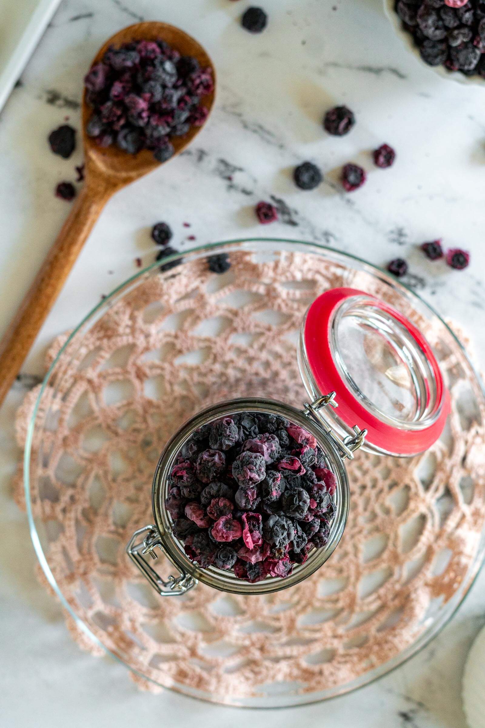 Dried blueberries in a mason jar and spoon. 