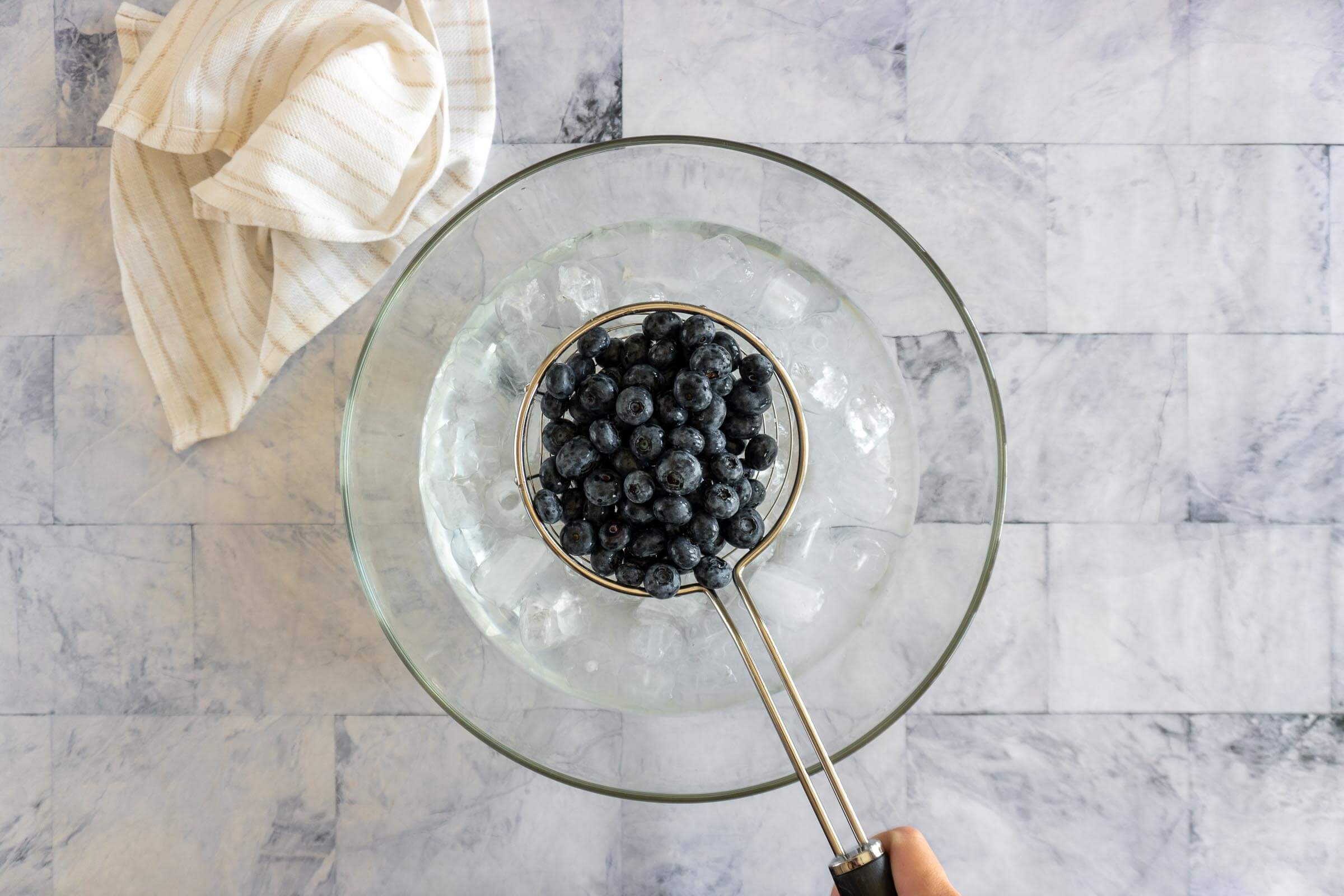 Cooling checked or blanched blueberries in an ice bath.
