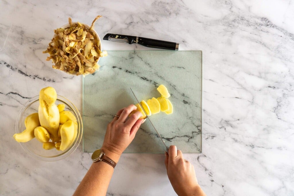 Slicing peeled ginger root.