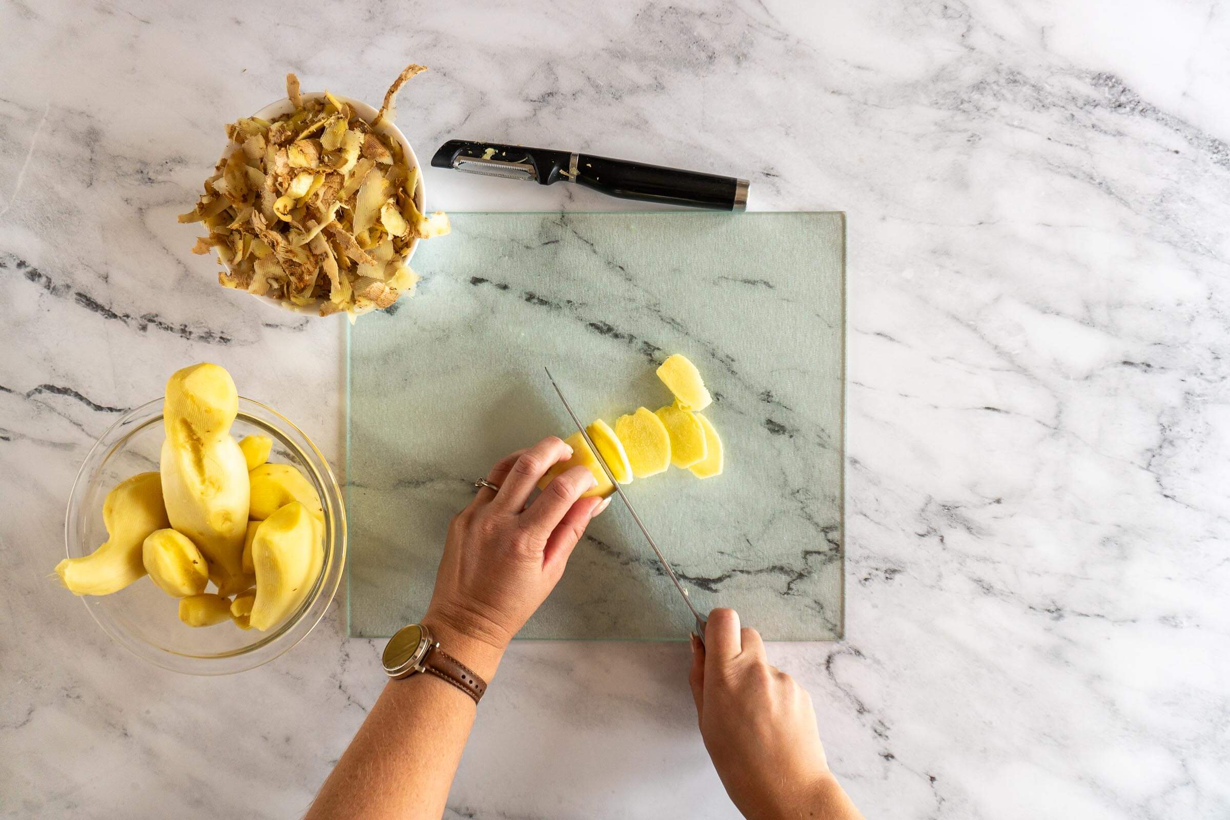 Slicing peeled ginger root. 