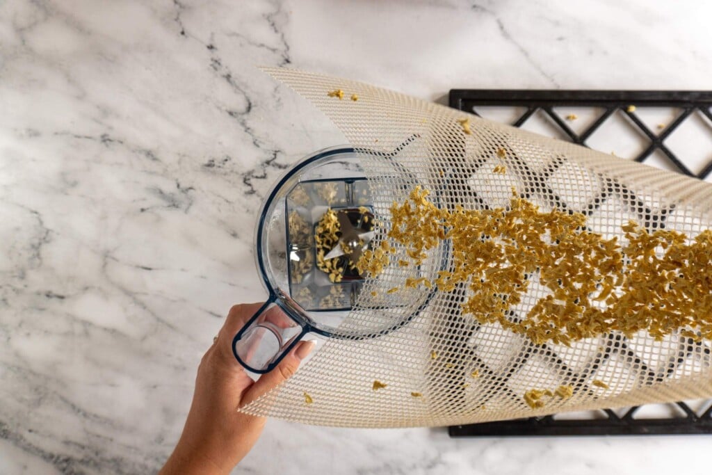 Transferring dried ginger to Vitamix dry goods jar.