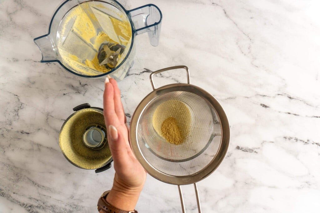 Shaking ground ginger through a mesh sieve.