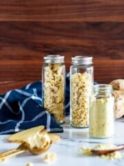 Dried sliced, minced, and ground ginger in glass jars.