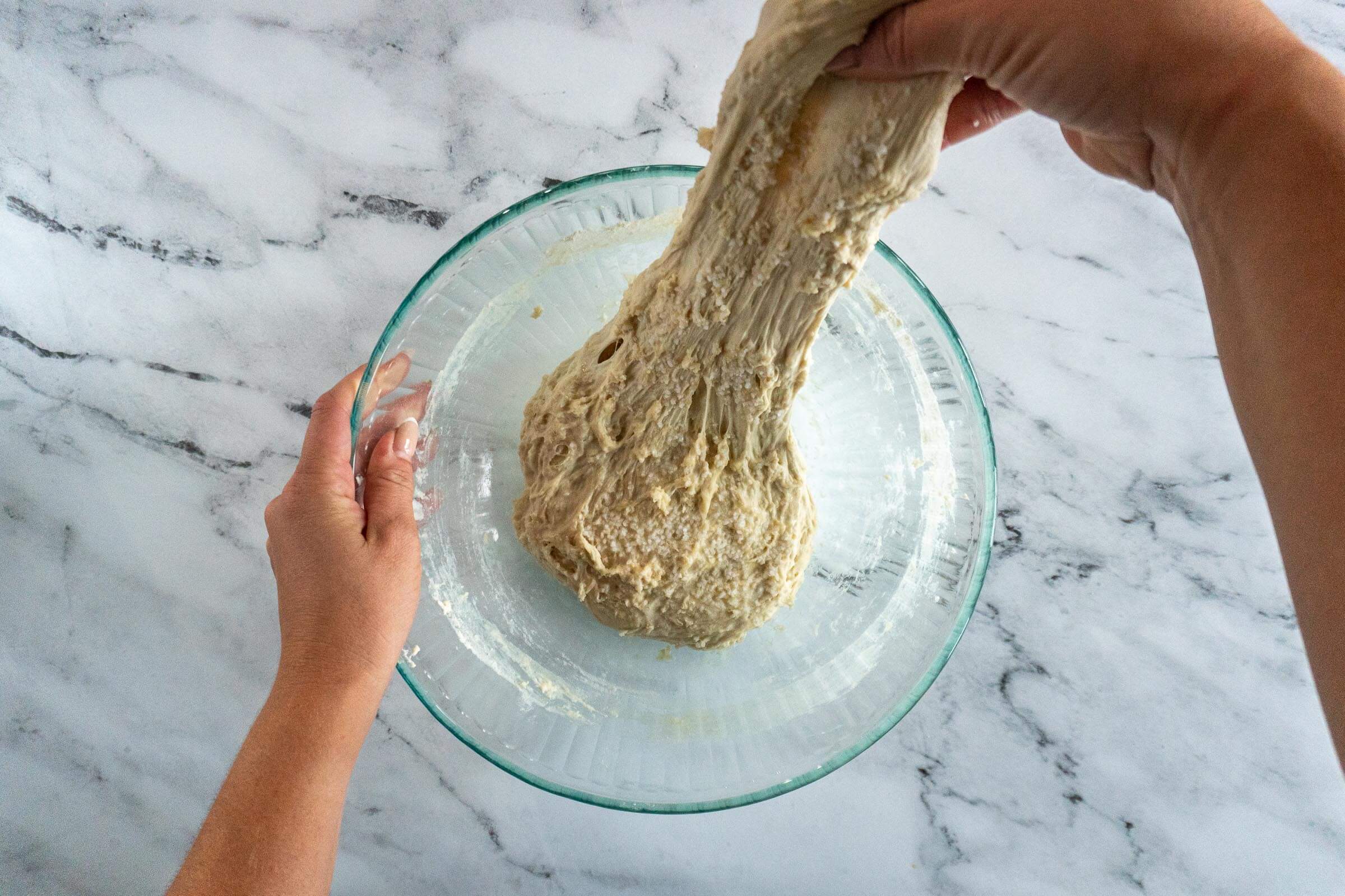 Pulling the dough to perform stretch and folds.