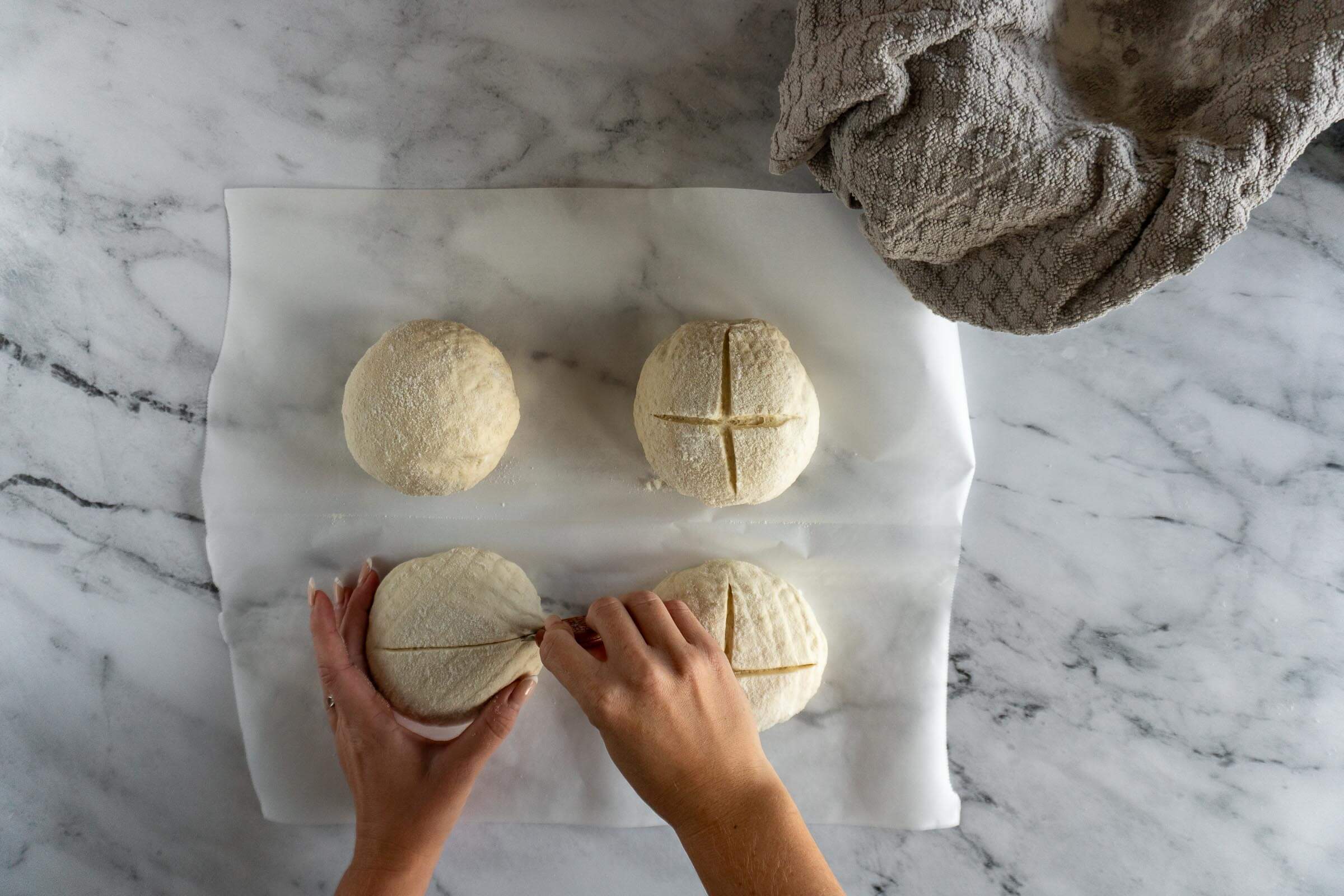 Scoring sourdough bread bowls.