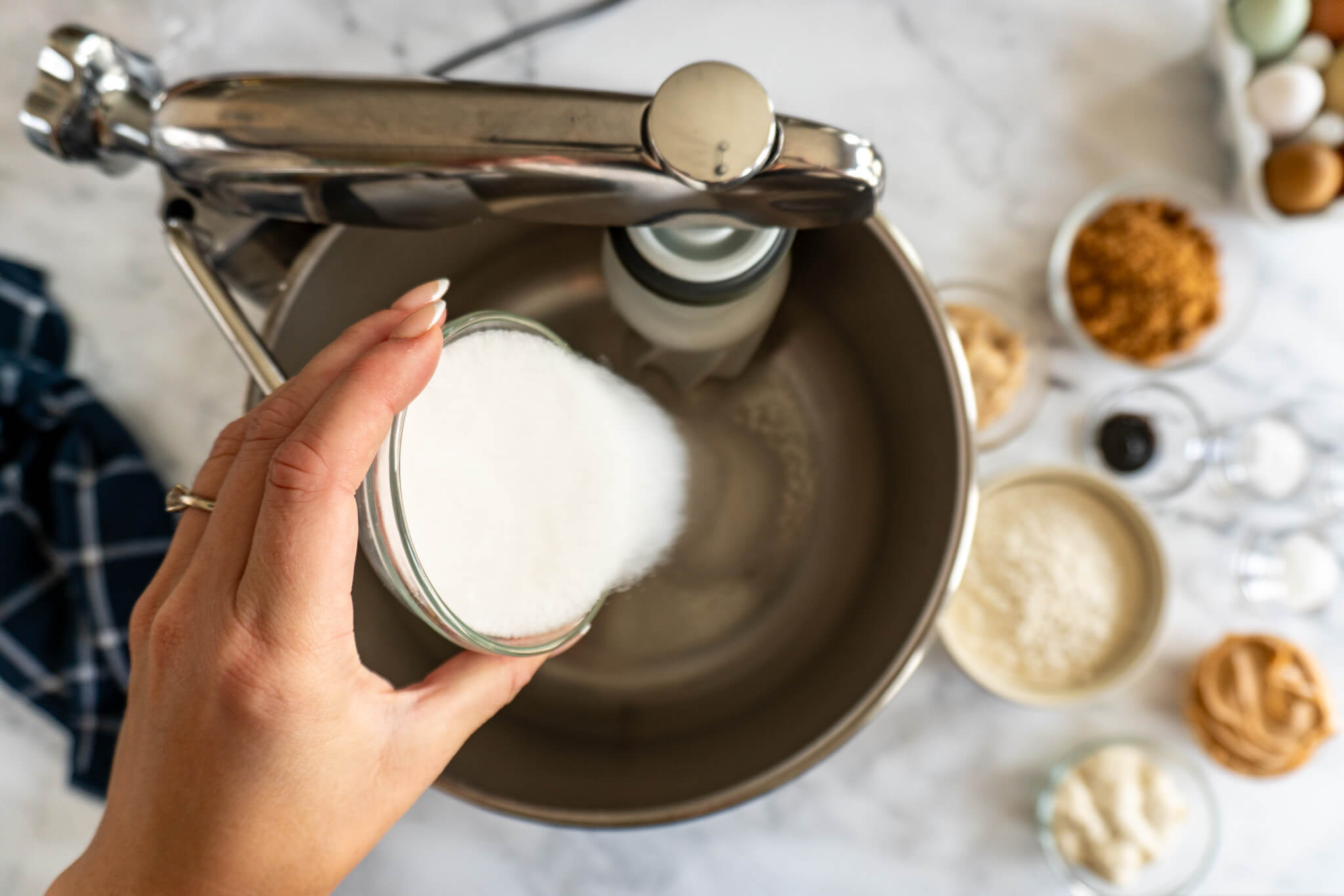 Adding sugar to Ankarsrum mixer. 