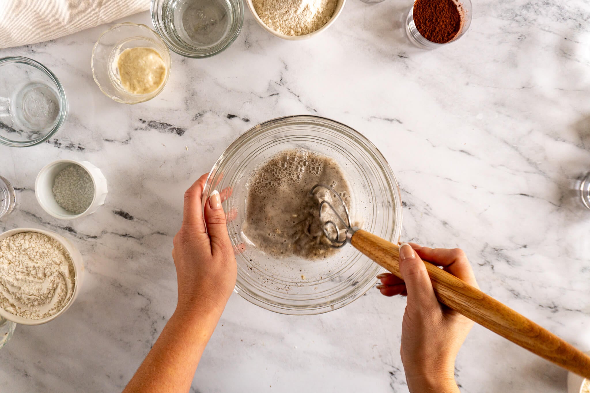 Mixing vanilla paste, water and sourdough starter. 