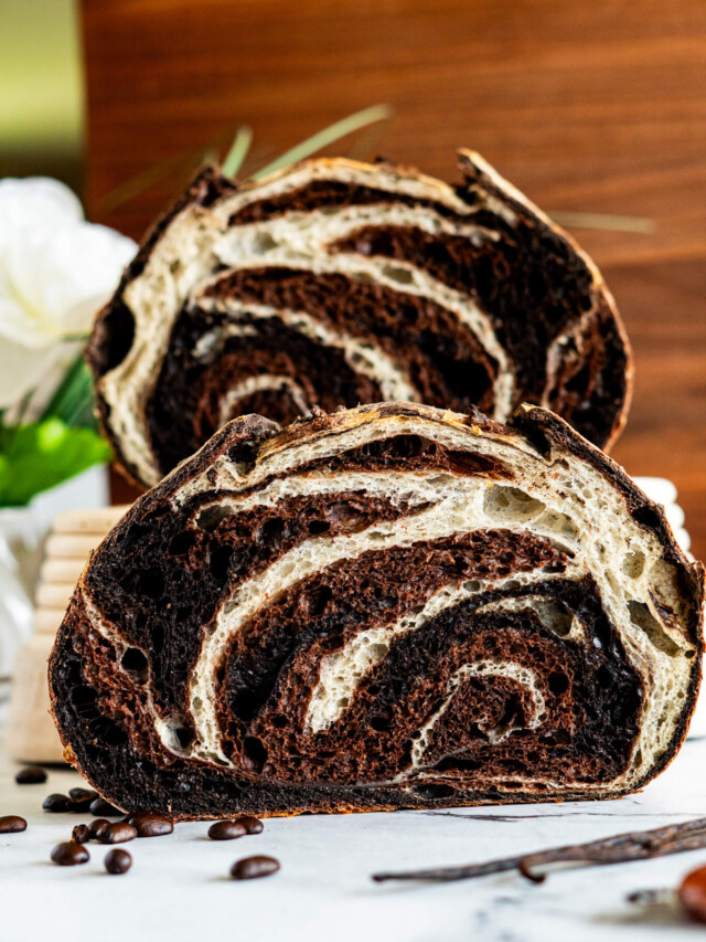 Chocolate vanilla swirl sourdough bread sliced in half showing the marbling.