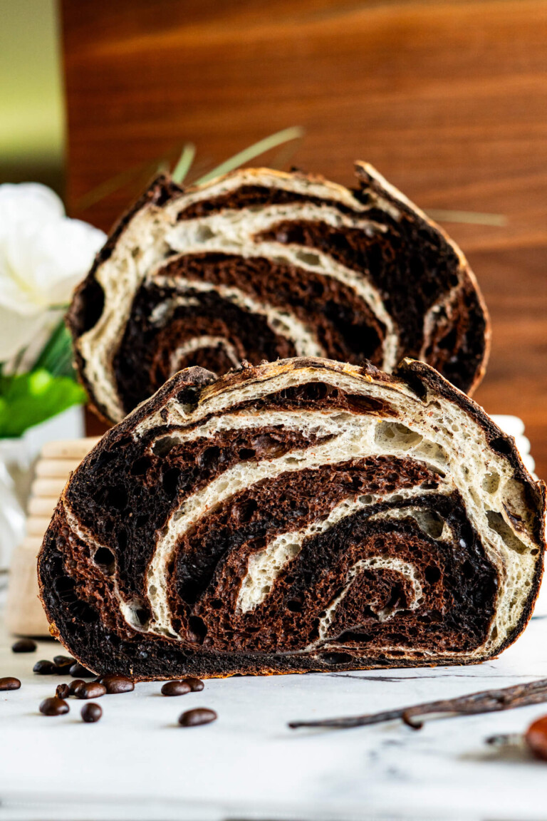 Chocolate vanilla swirl sourdough bread sliced in half showing the marbling.
